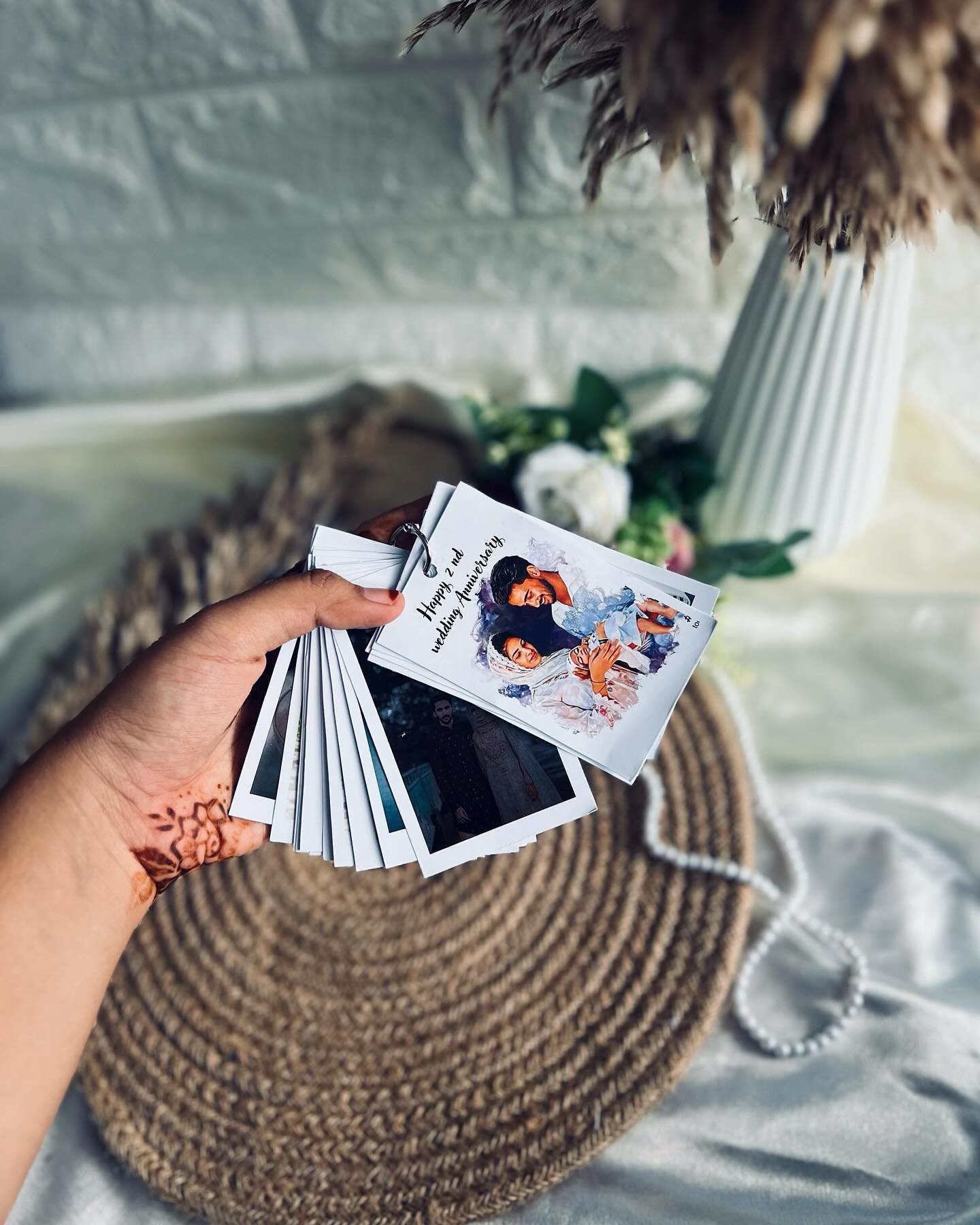 A ring-bound flip book of personalized wedding anniversary photo cards.