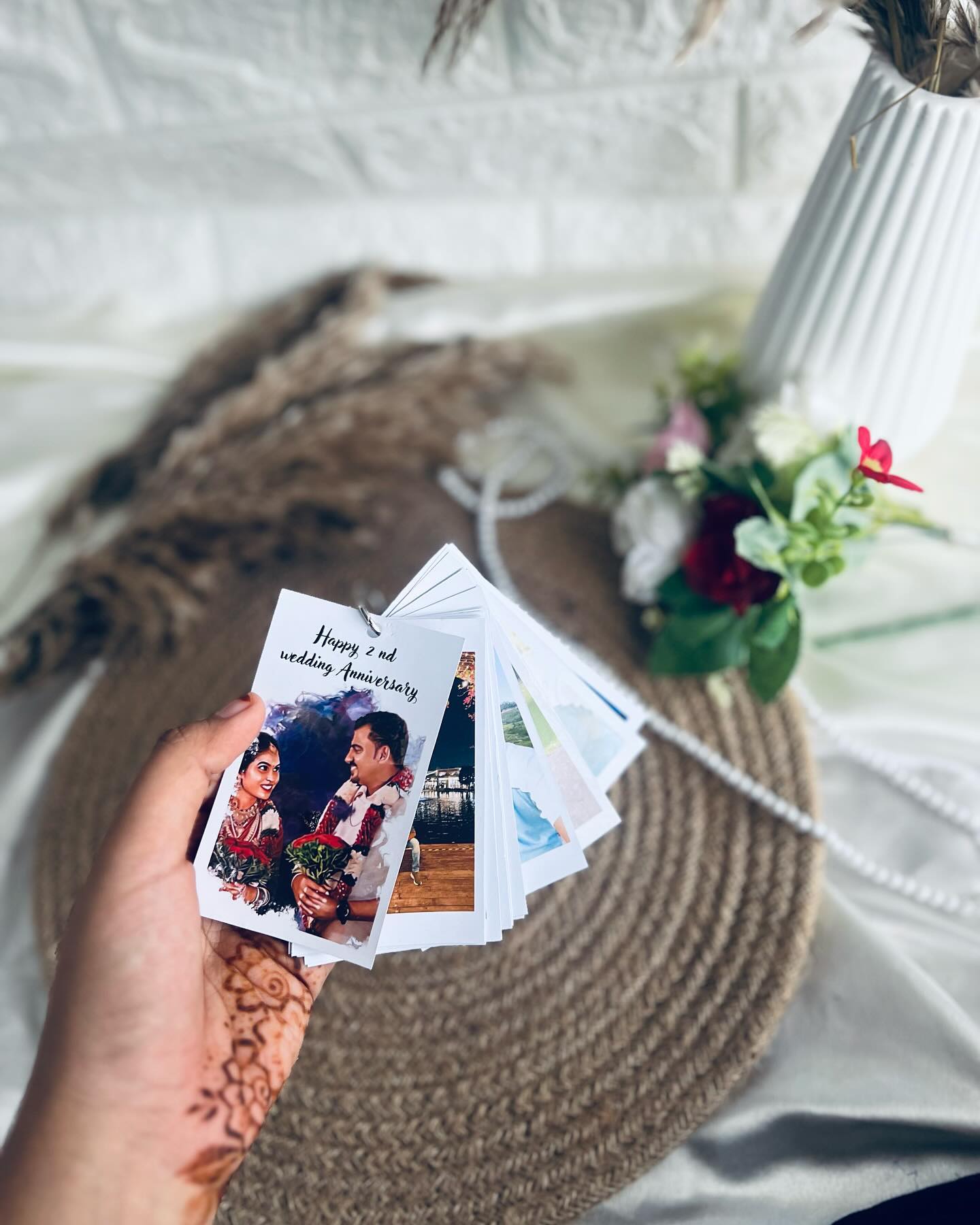 A personalized fan of ringed photo cards chronicling a couple's journey, opening with 'Happy 2nd Wedding Anniversary.'