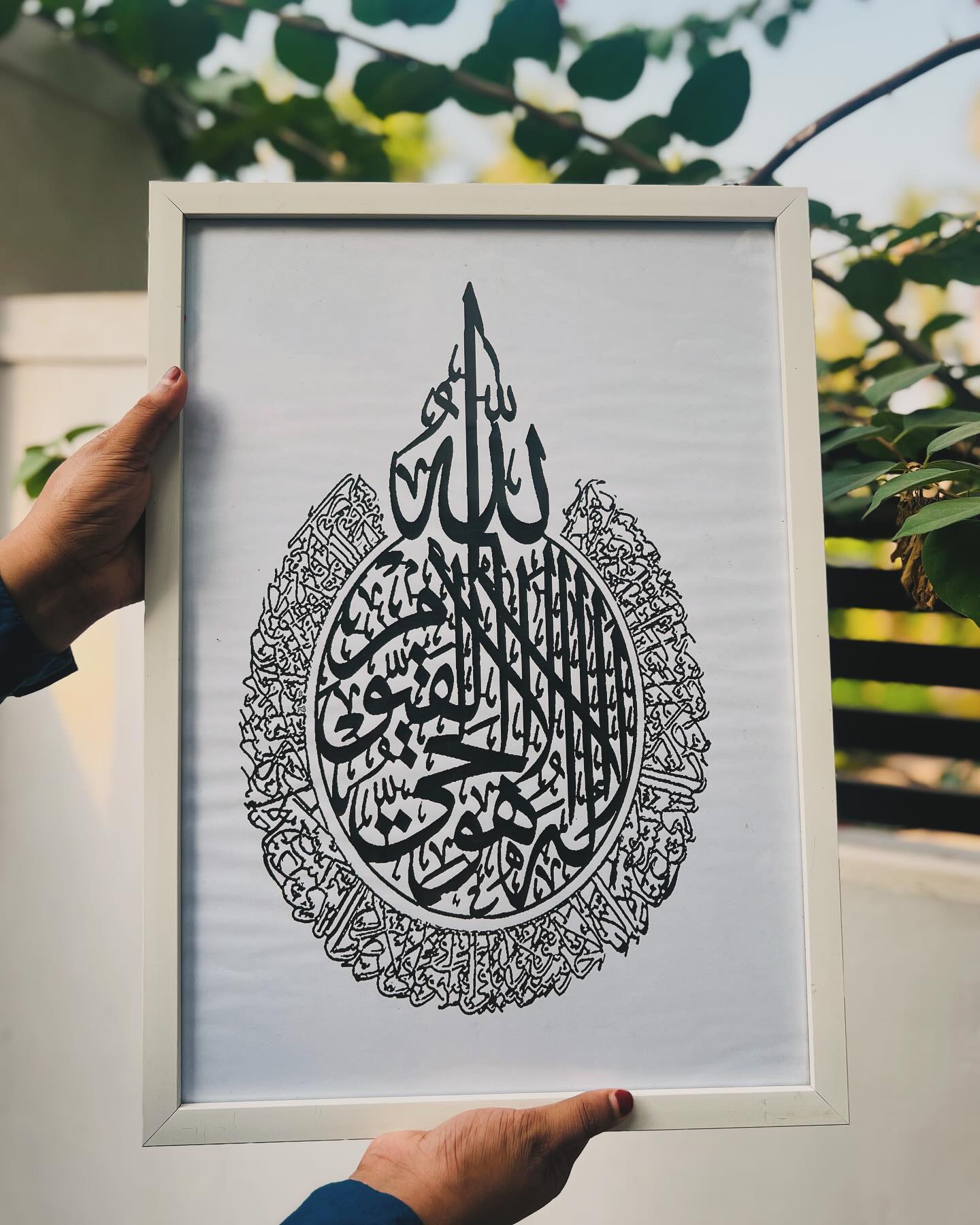 A framed black-and-white Islamic calligraphy print featuring intricate Ayat al-Kursi artwork.