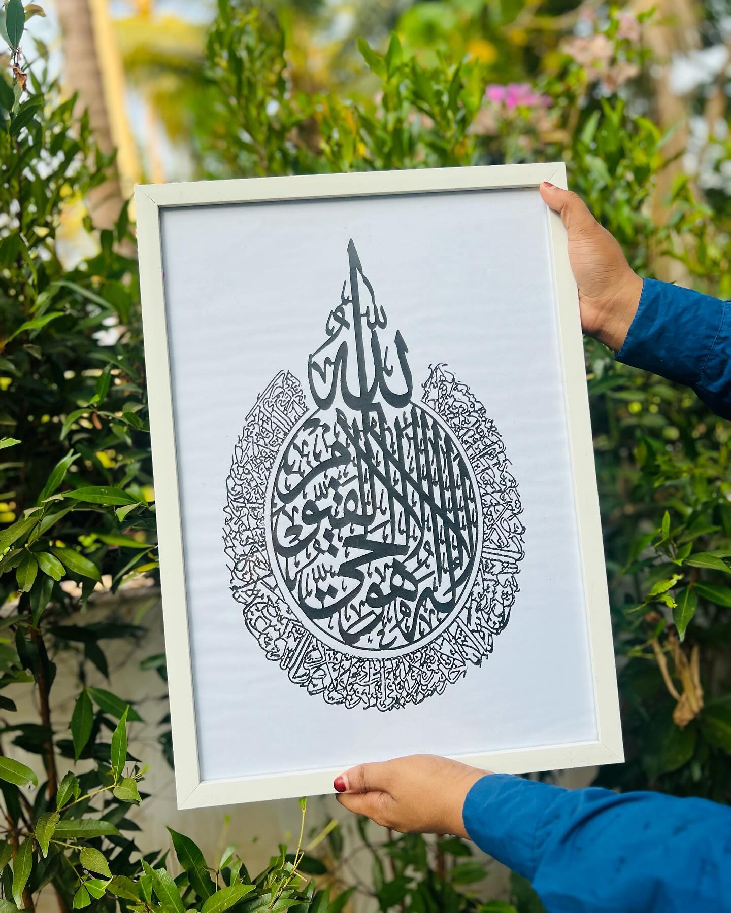 A framed Islamic calligraphy print in elegant black script on a clean white background.