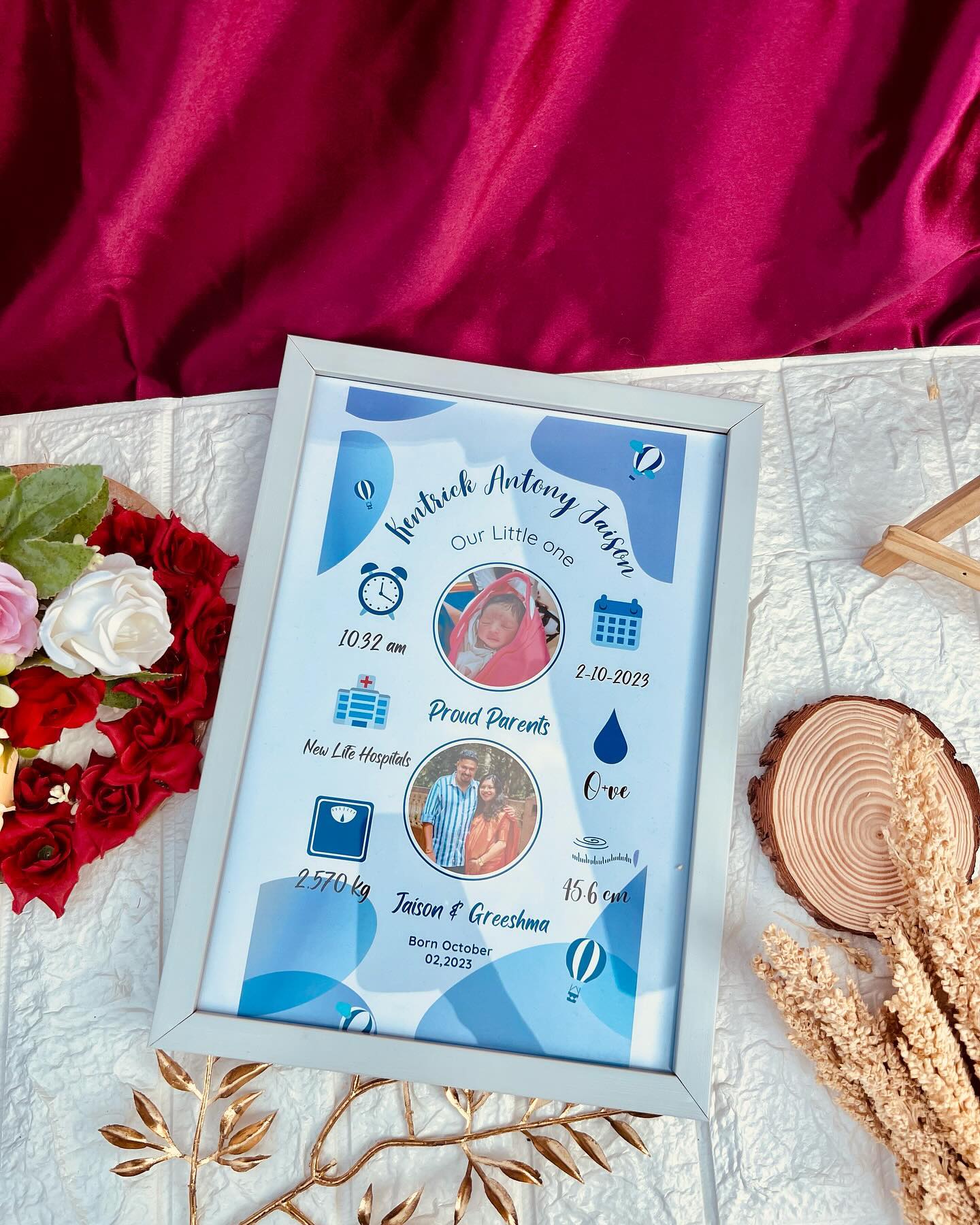 A soft blue framed keepsake announcing a newborn's arrival with photos, name, and birth details.