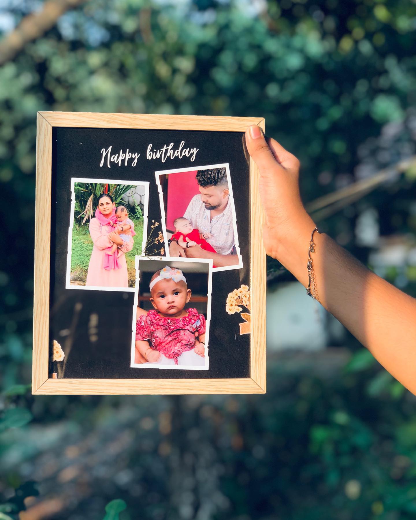 A black scrapbook-style frame with torn-paper family photo cutouts and a handwritten 'Happy Birthday' caption.