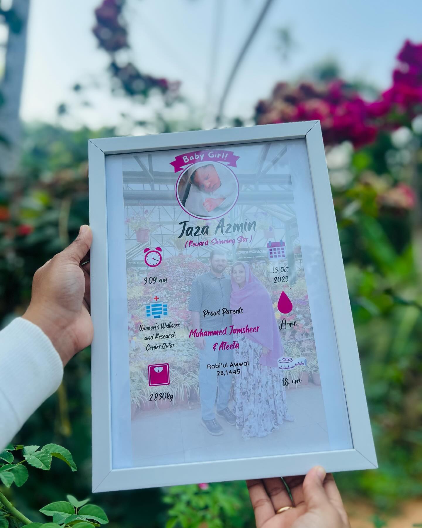 A framed birth-announcement poster with the newborn's name, stats, and family photo.
