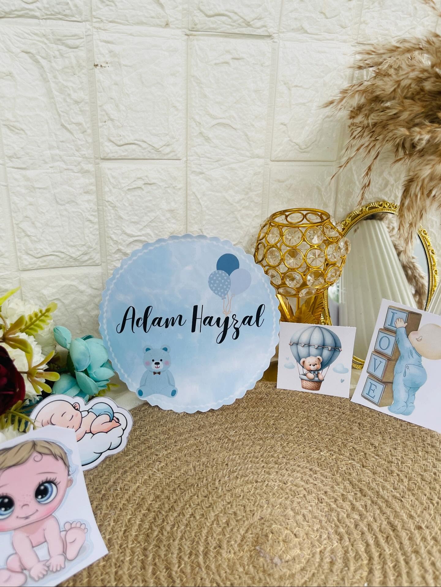 A soft blue nursery decor set personalized with baby's name and cute teddy bear accents.