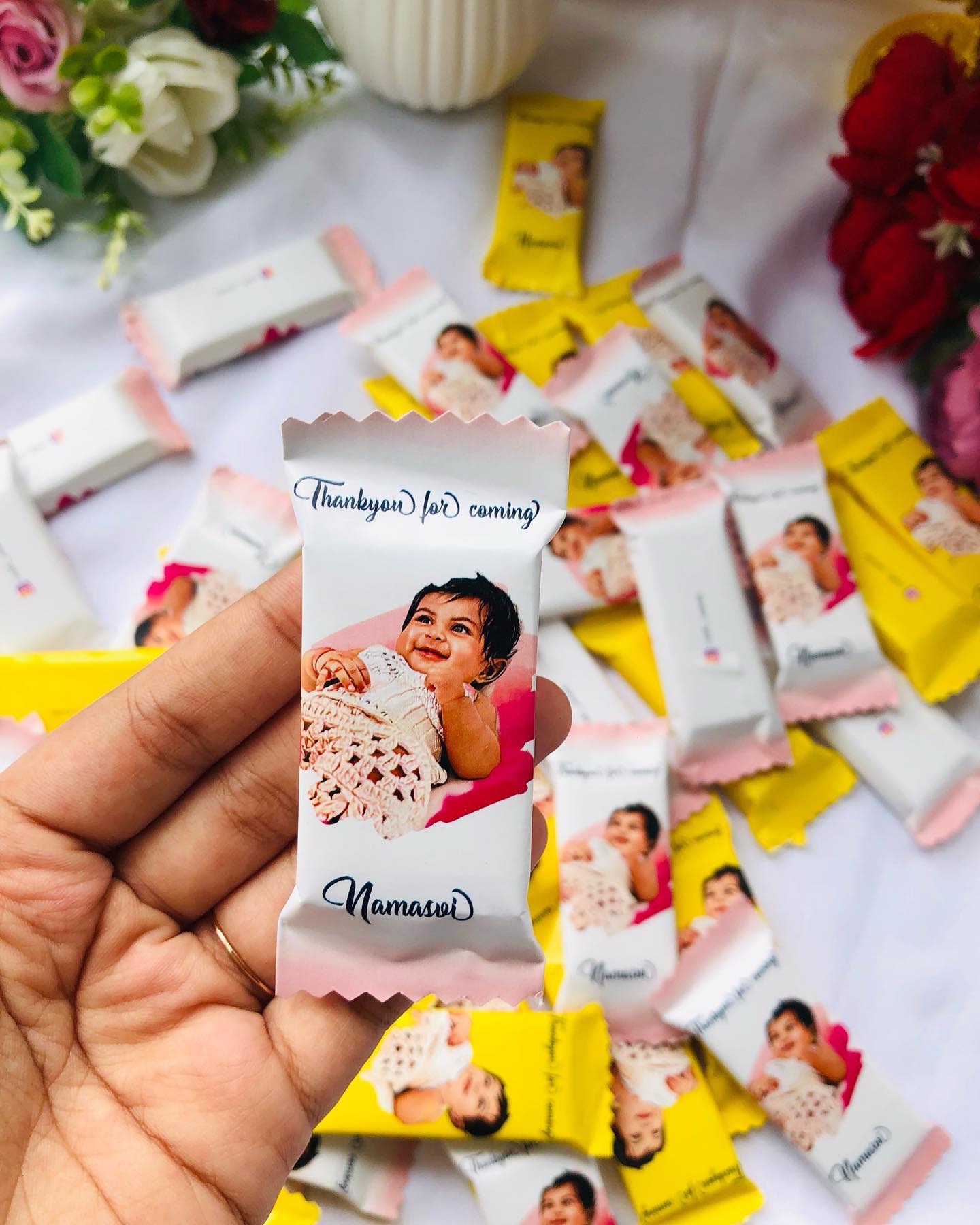 A set of personalized mini chocolate bars printed with a baby's photo, name, and a 'Thank you for coming' message.