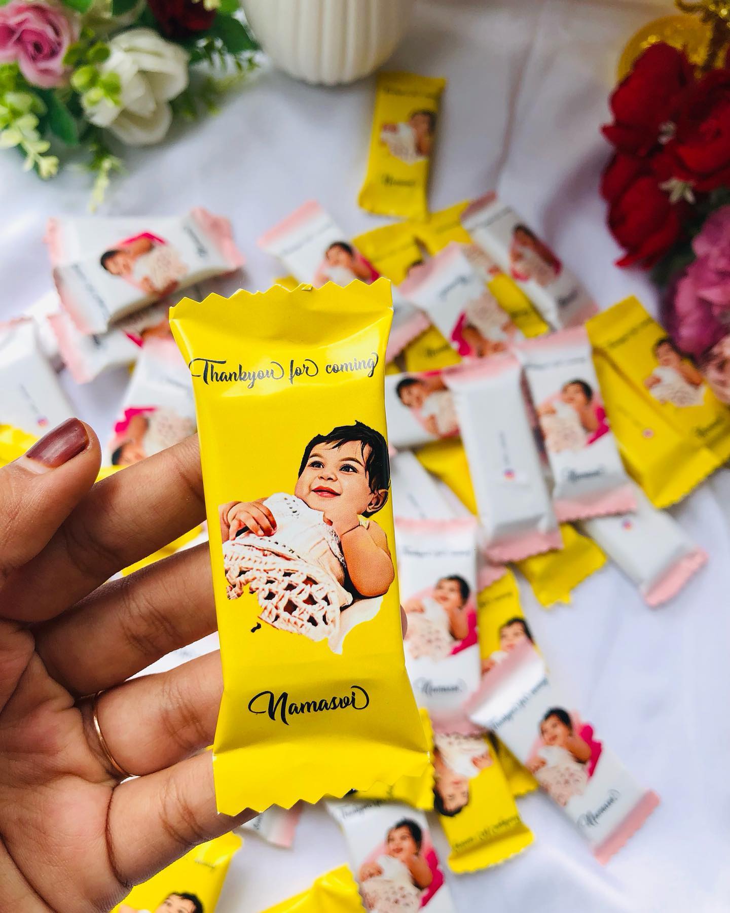 Personalized chocolate favor bars printed with a baby's photo, name, and a 'Thank You for Coming' message.