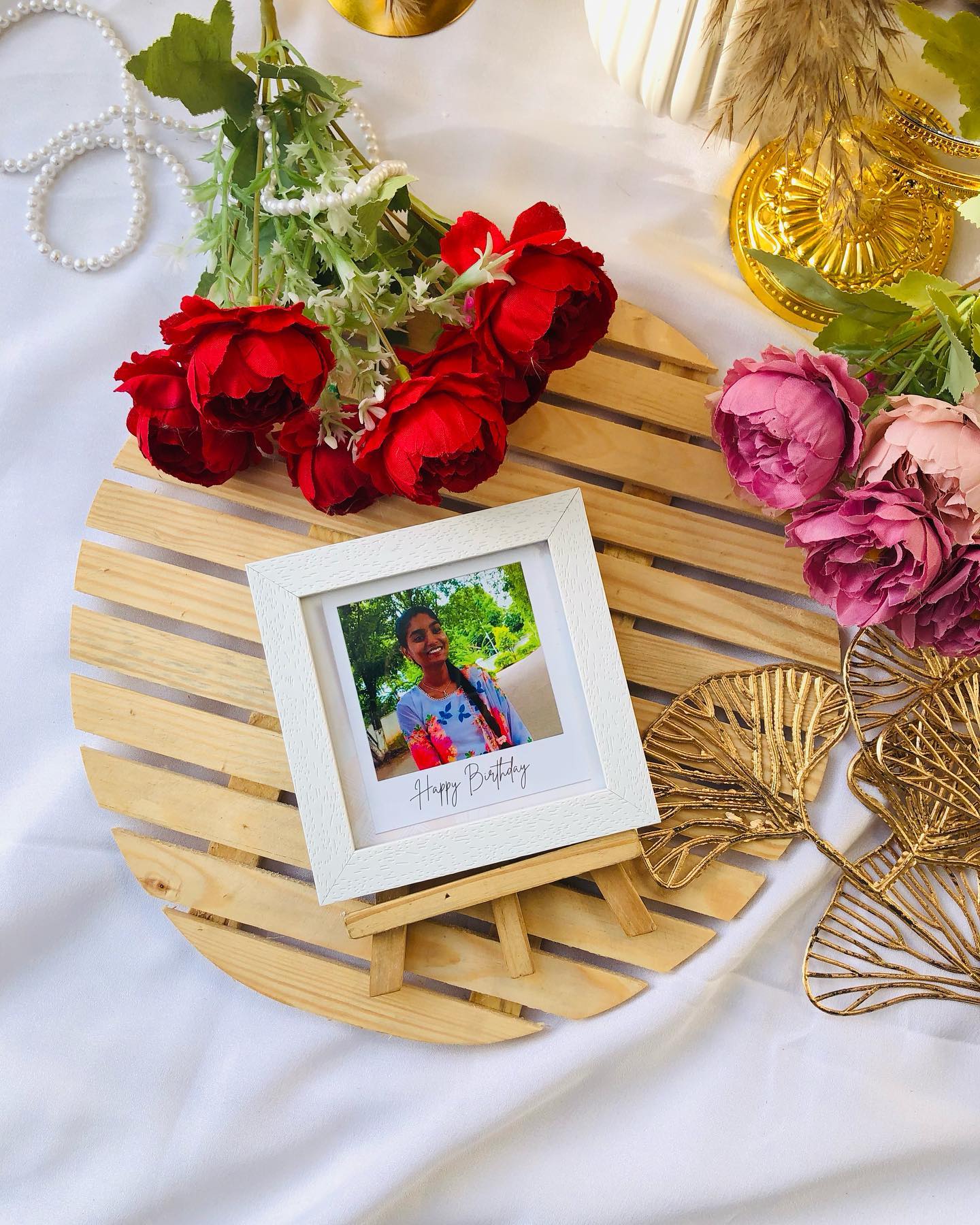 A white mini photo frame on a wooden easel, personalized with a portrait and a 'Happy Birthday' message.