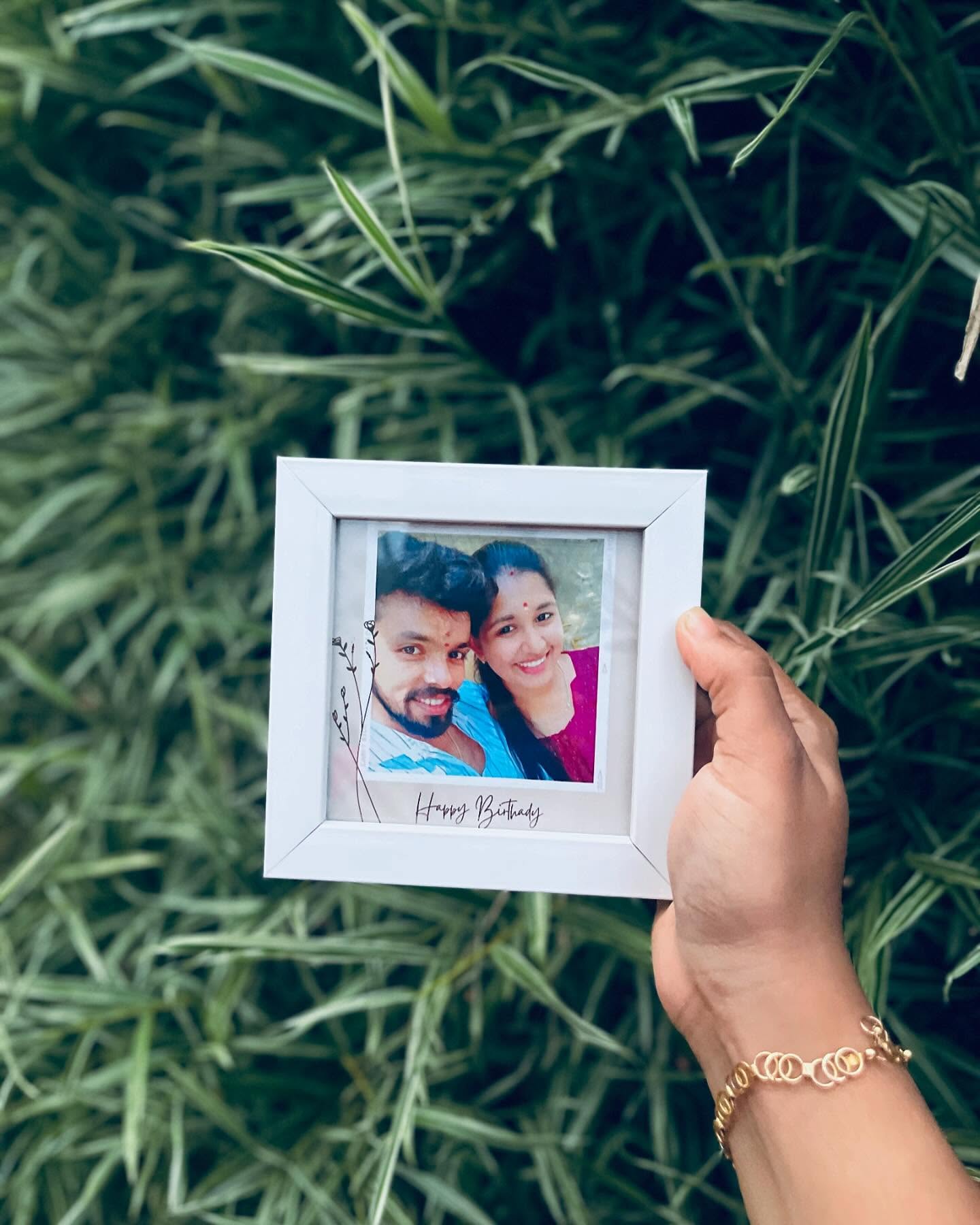 A polaroid-style mini frame with a couple's photo and a handwritten-style 'Happy Birthday' note.