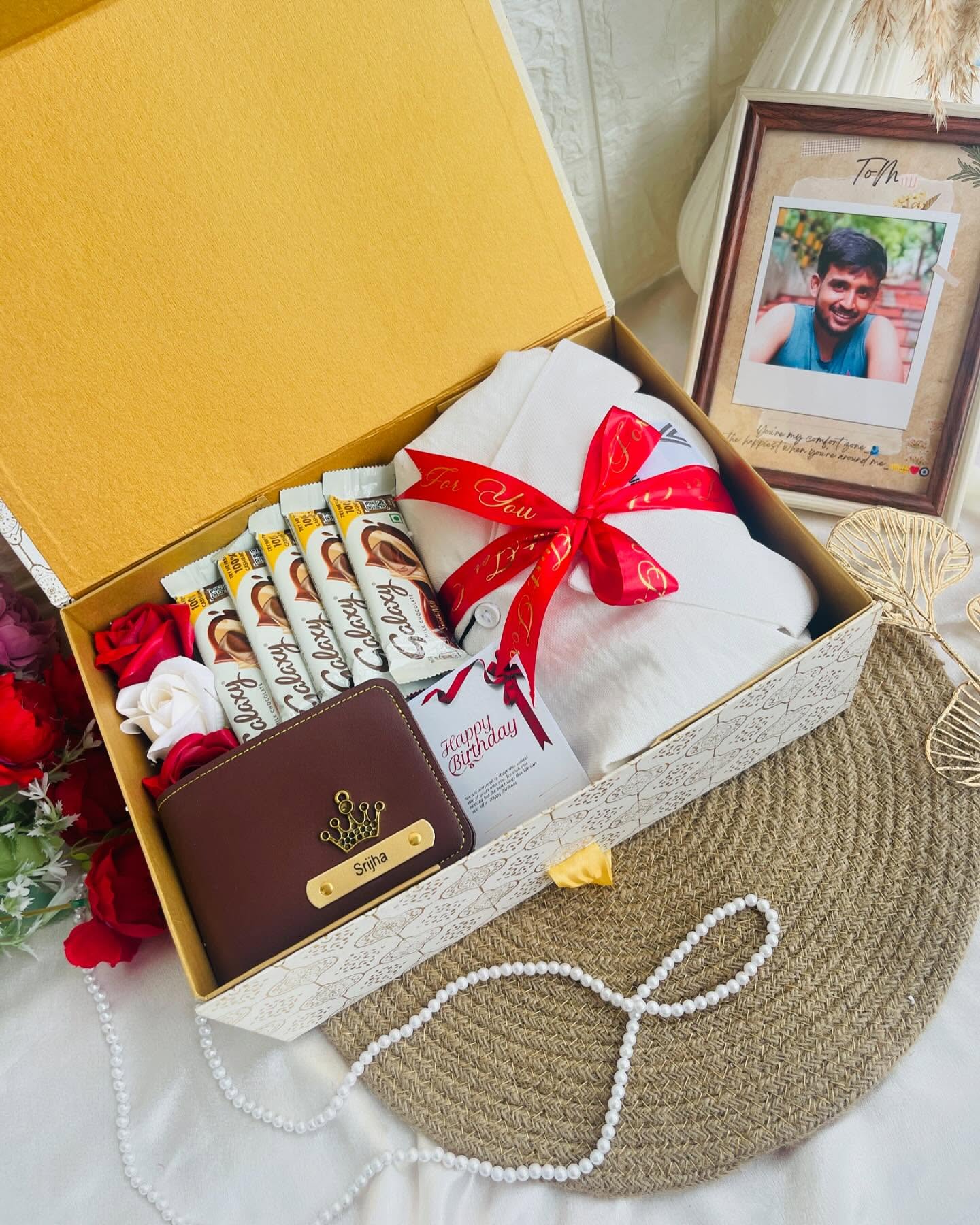 A cosy white robe, Galaxy chocolate bars and a name-engraved wallet packed in a golden birthday gift box.