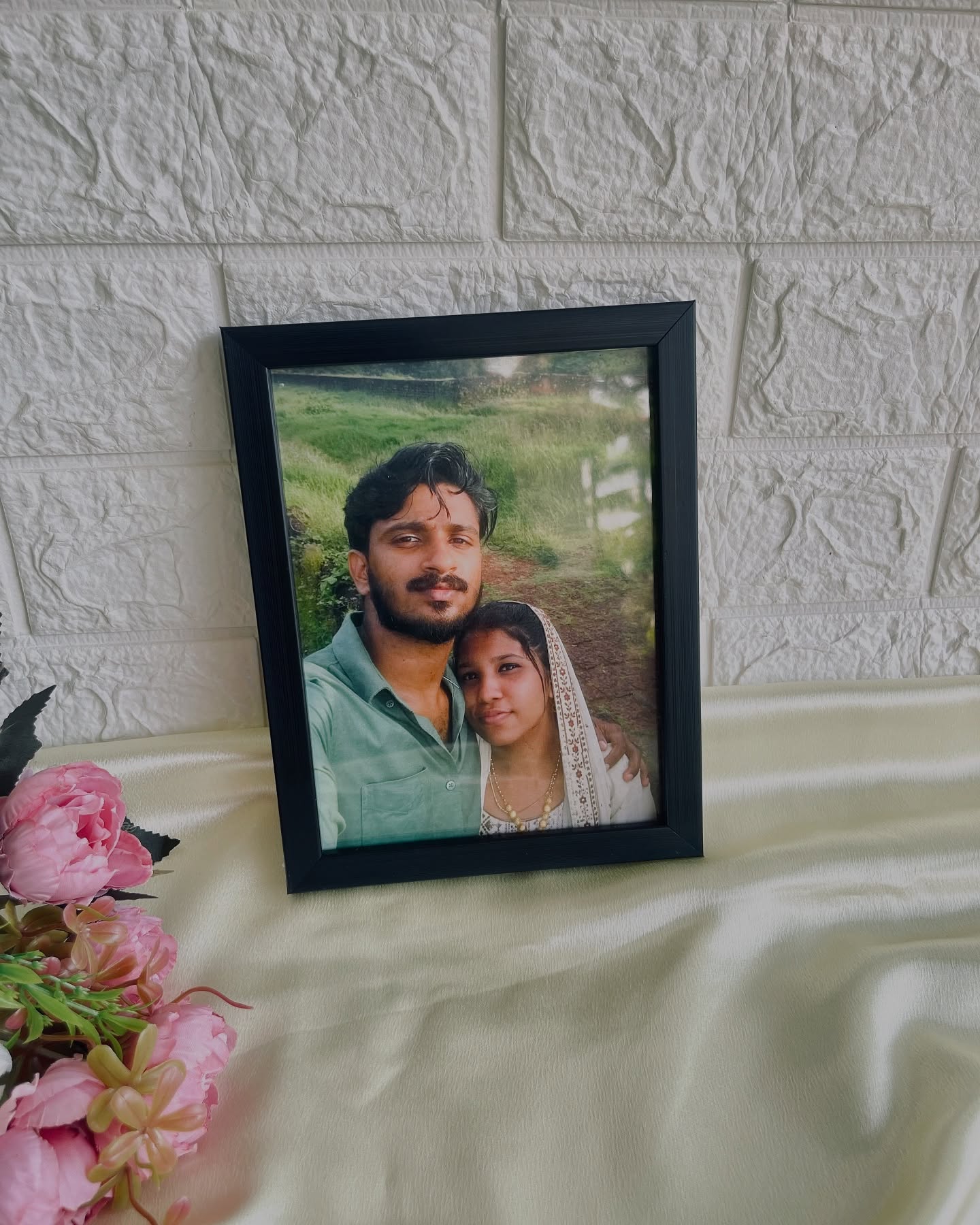 A framed keepsake photo styled with soft pink blooms for a heartfelt, personal gift.