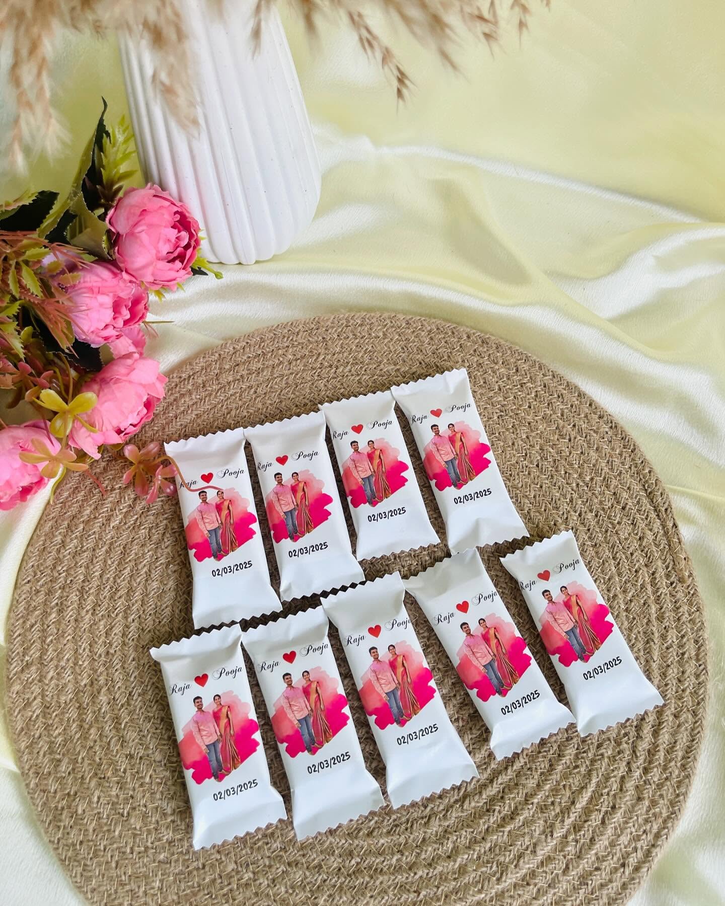 A set of mini chocolate bars individually wrapped with the couple's photo, names, and wedding date for a sweet party favor.