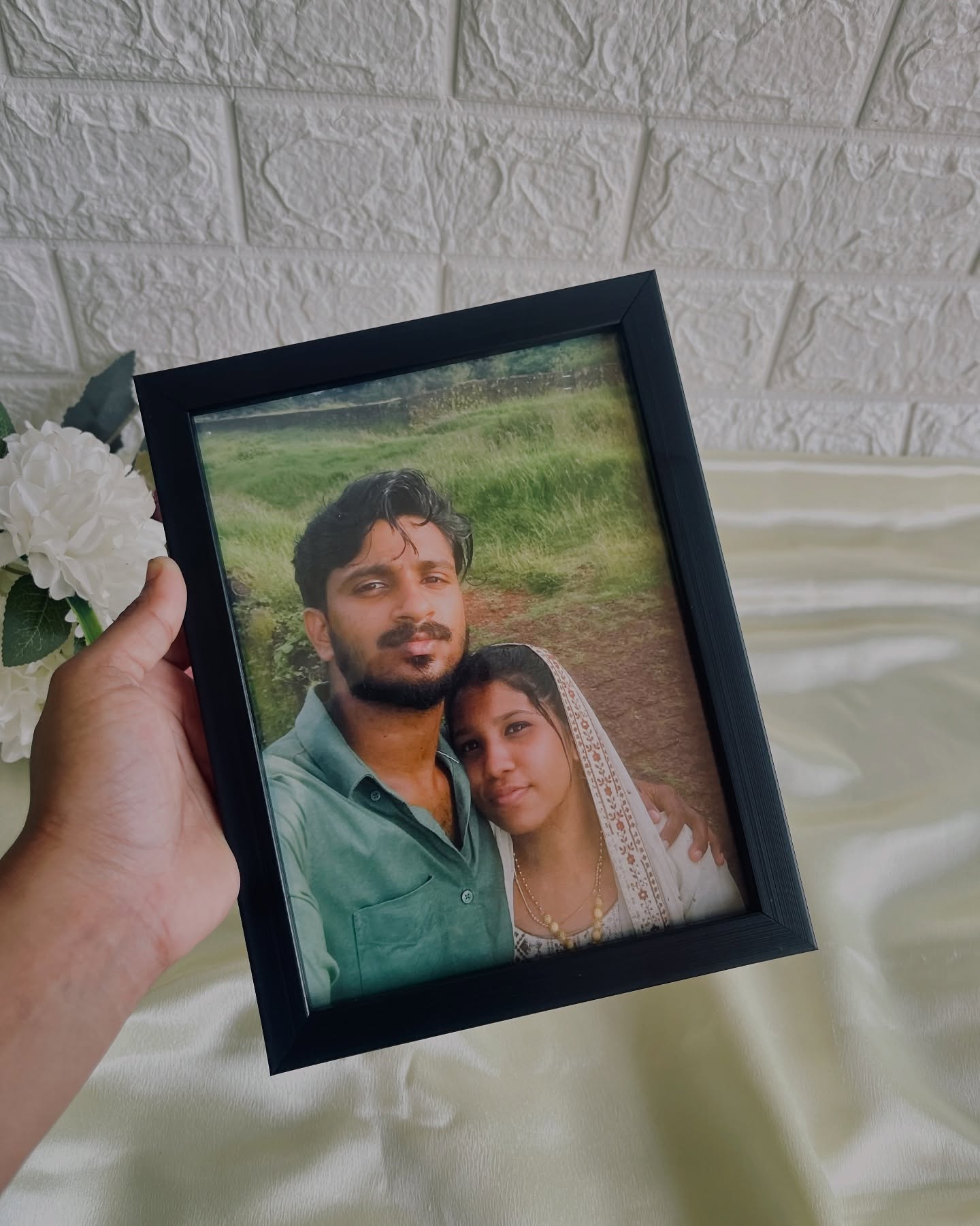 A warm, personalized wooden photo frame featuring a couple's candid outdoor portrait.