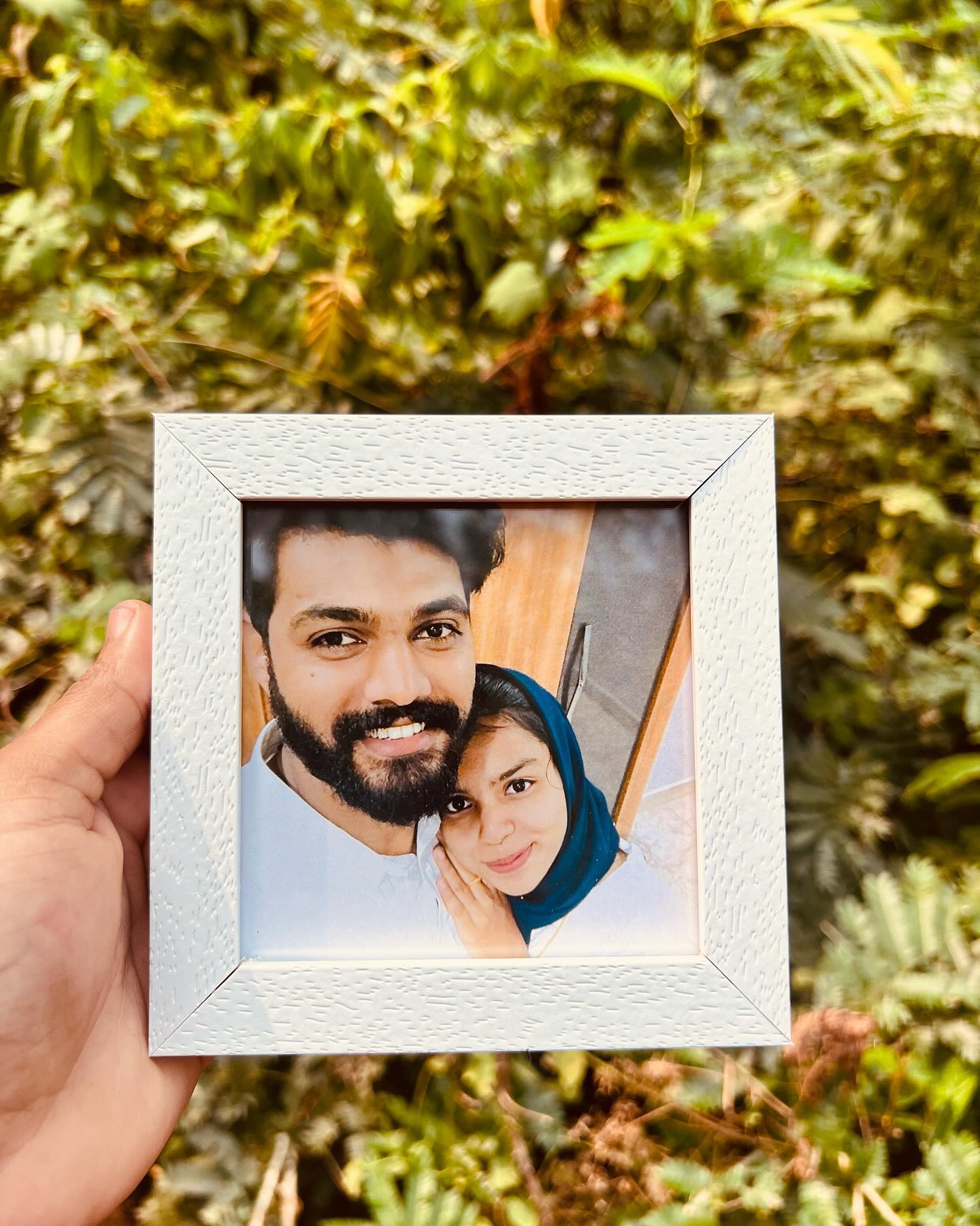A compact textured-white photo frame personalized with a favourite couple portrait.