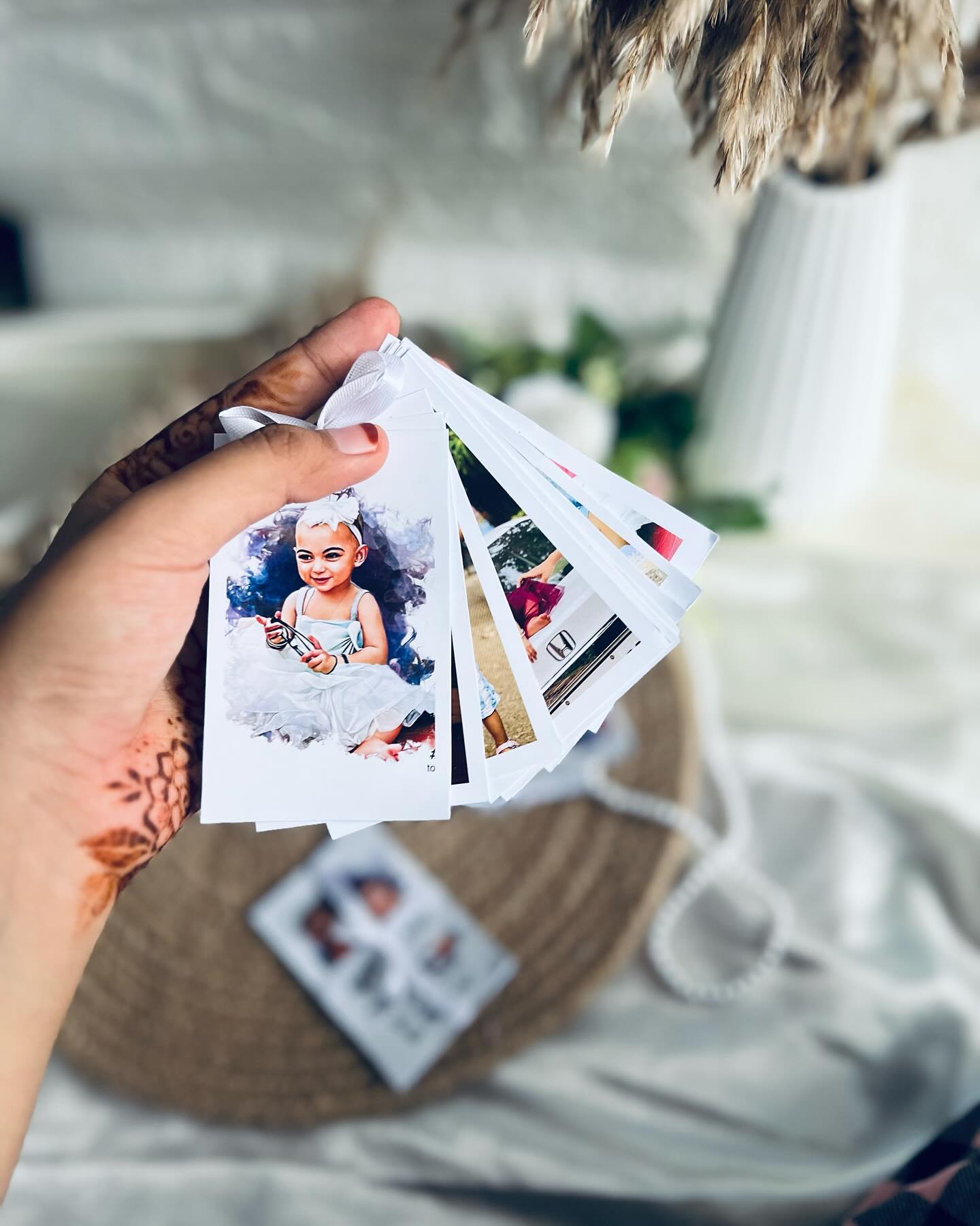 A fanned stack of custom-printed photo cards bound together on a ribbon, a personal keepsake of favorite moments.