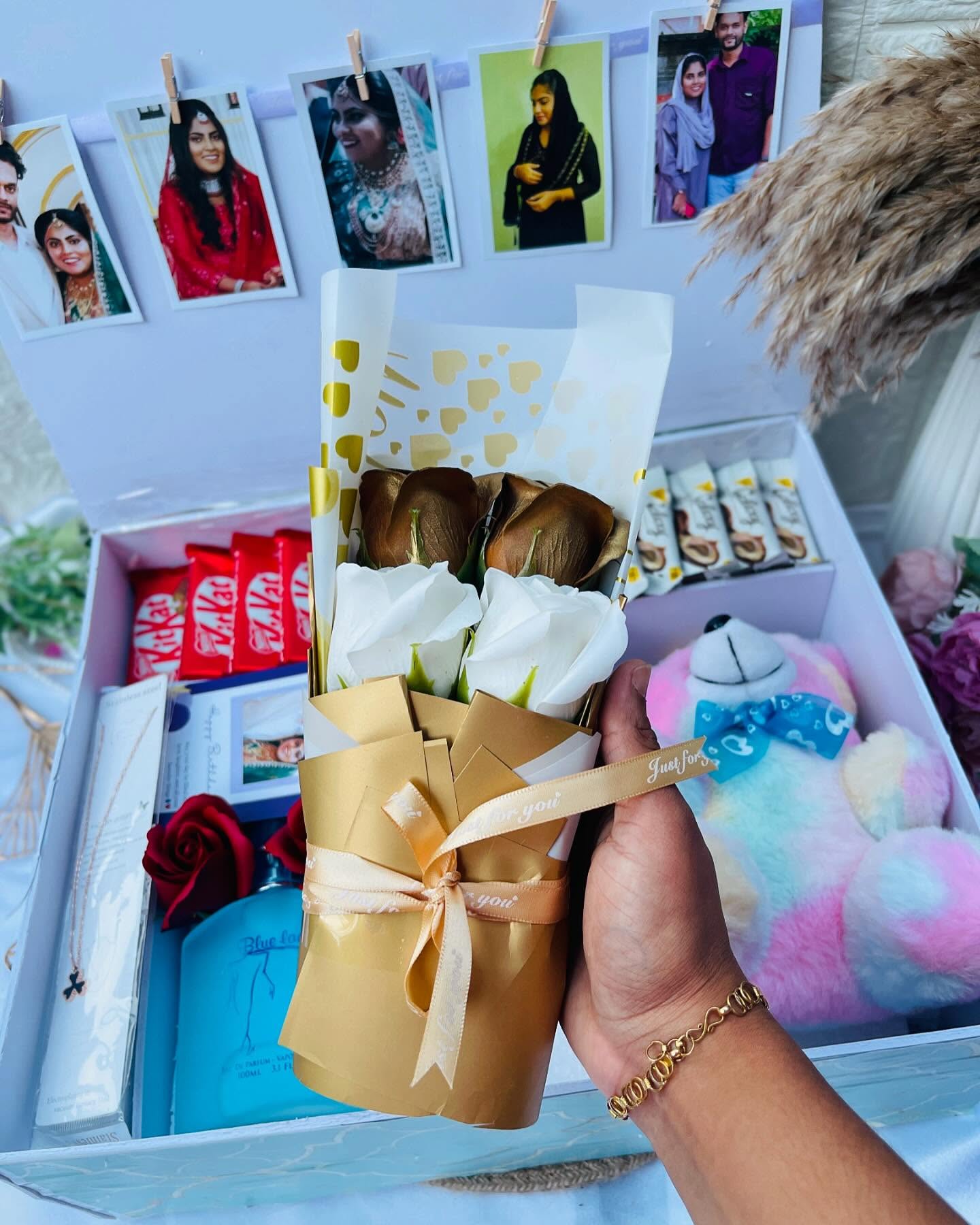 A generously packed birthday box with a personalized couple photo card, chocolates, perfume, a teddy, and a necklace.
