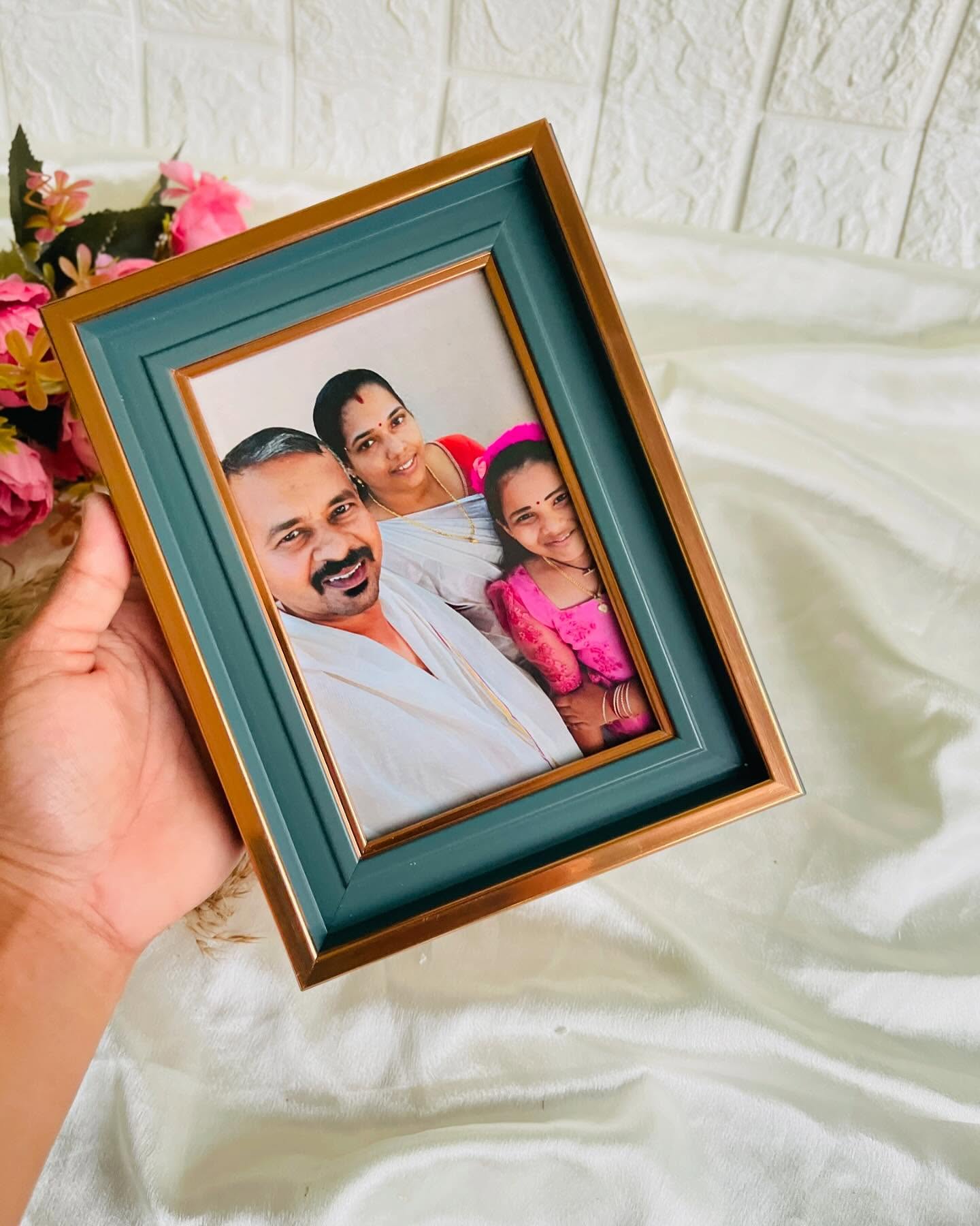 A personalized framed family photo set in a rich teal and gold border.