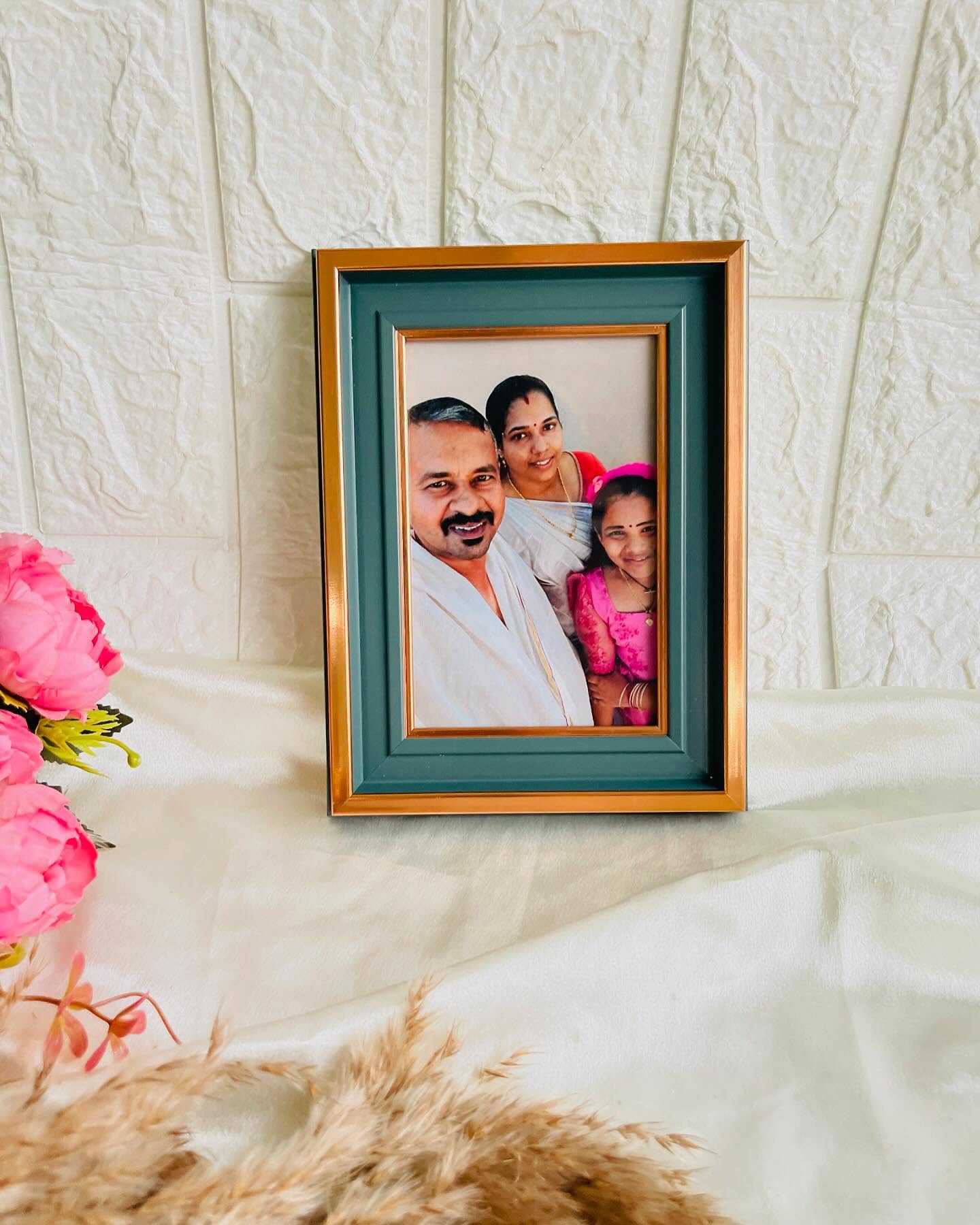 A teal and gold photo frame showcasing a warm family portrait, ready for any home or gifting occasion.