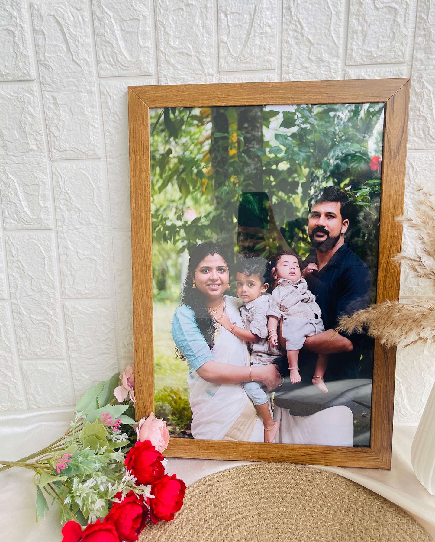 A warm wooden frame personalized with a joyful family portrait of parents and their two children.