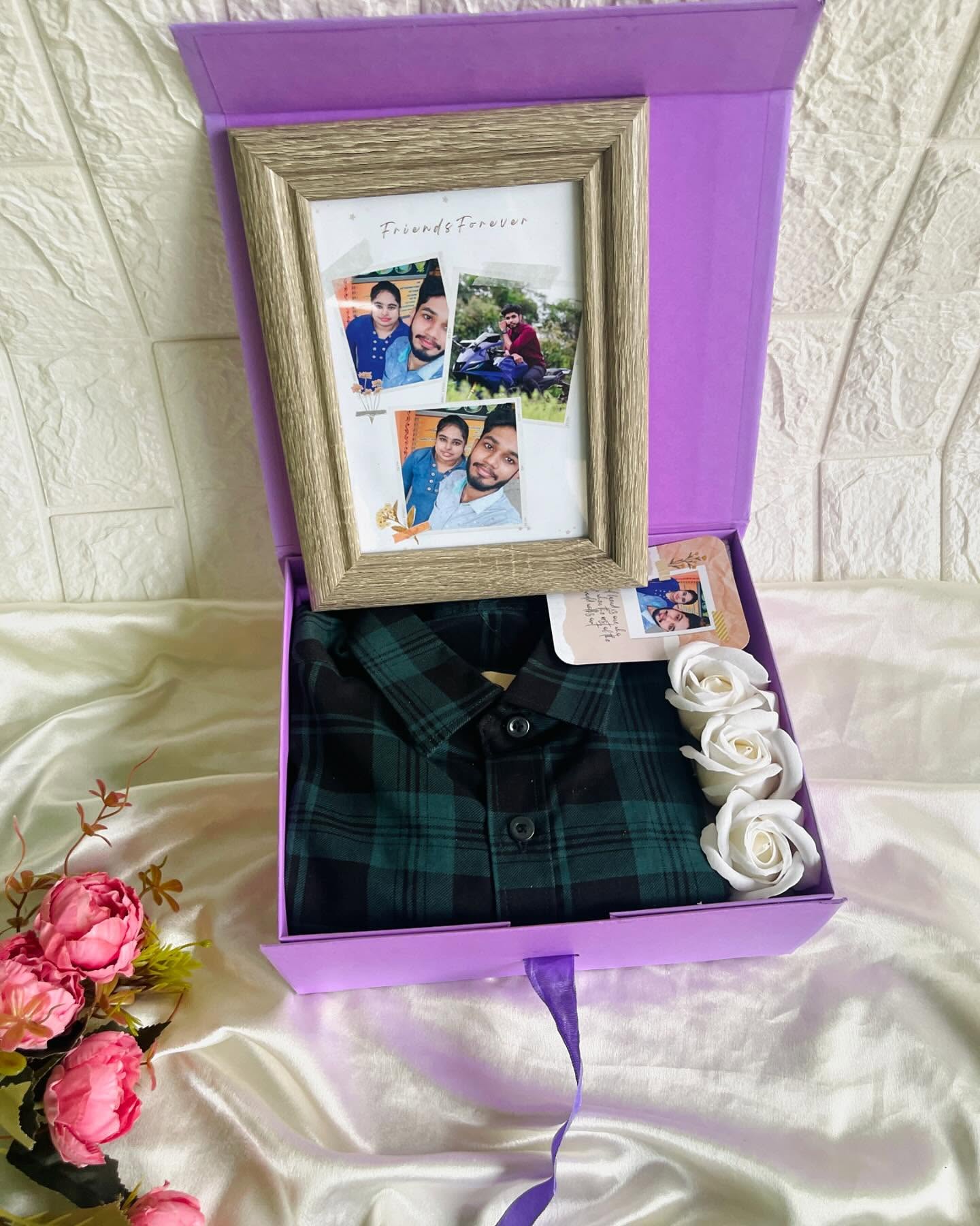 A lilac gift box pairing a personalized 'Friends Forever' photo frame with a cosy checked flannel shirt and white roses.
