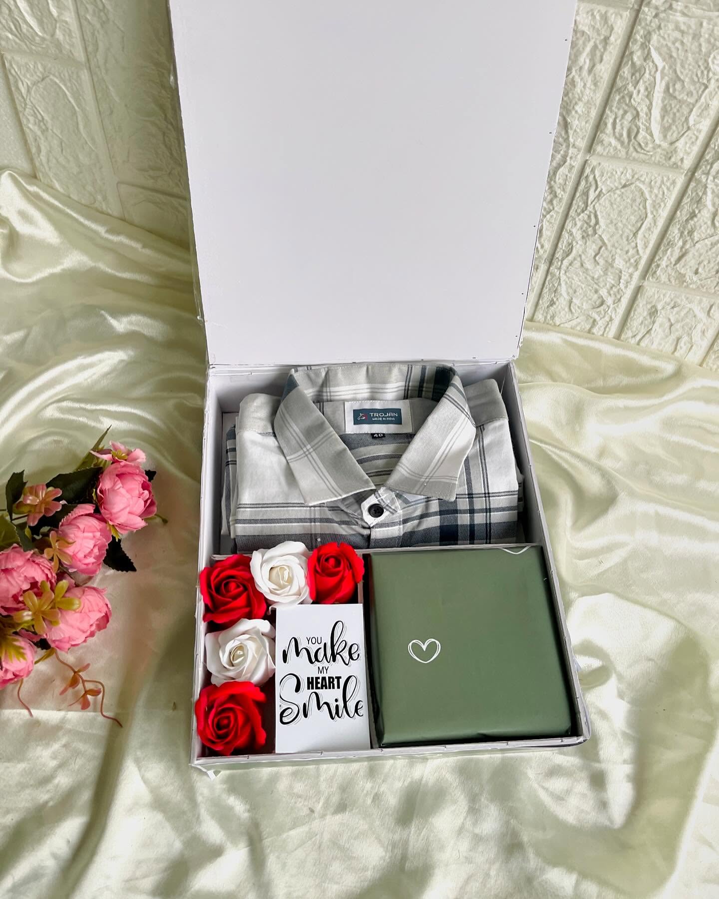 A crisp checked flannel shirt paired with roses, a heartfelt note, and a wrapped gift box for a romantic surprise.