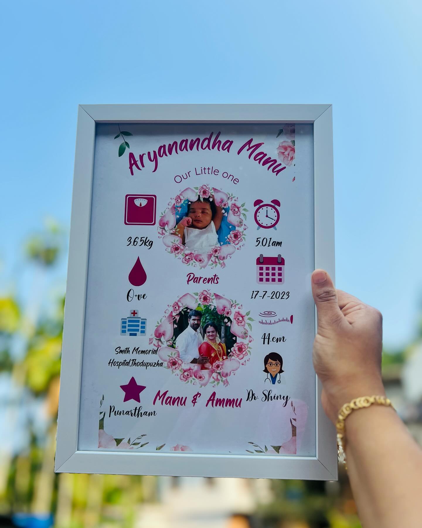 A pastel purple keepsake frame announcing a newborn's arrival with photos of baby and parents.