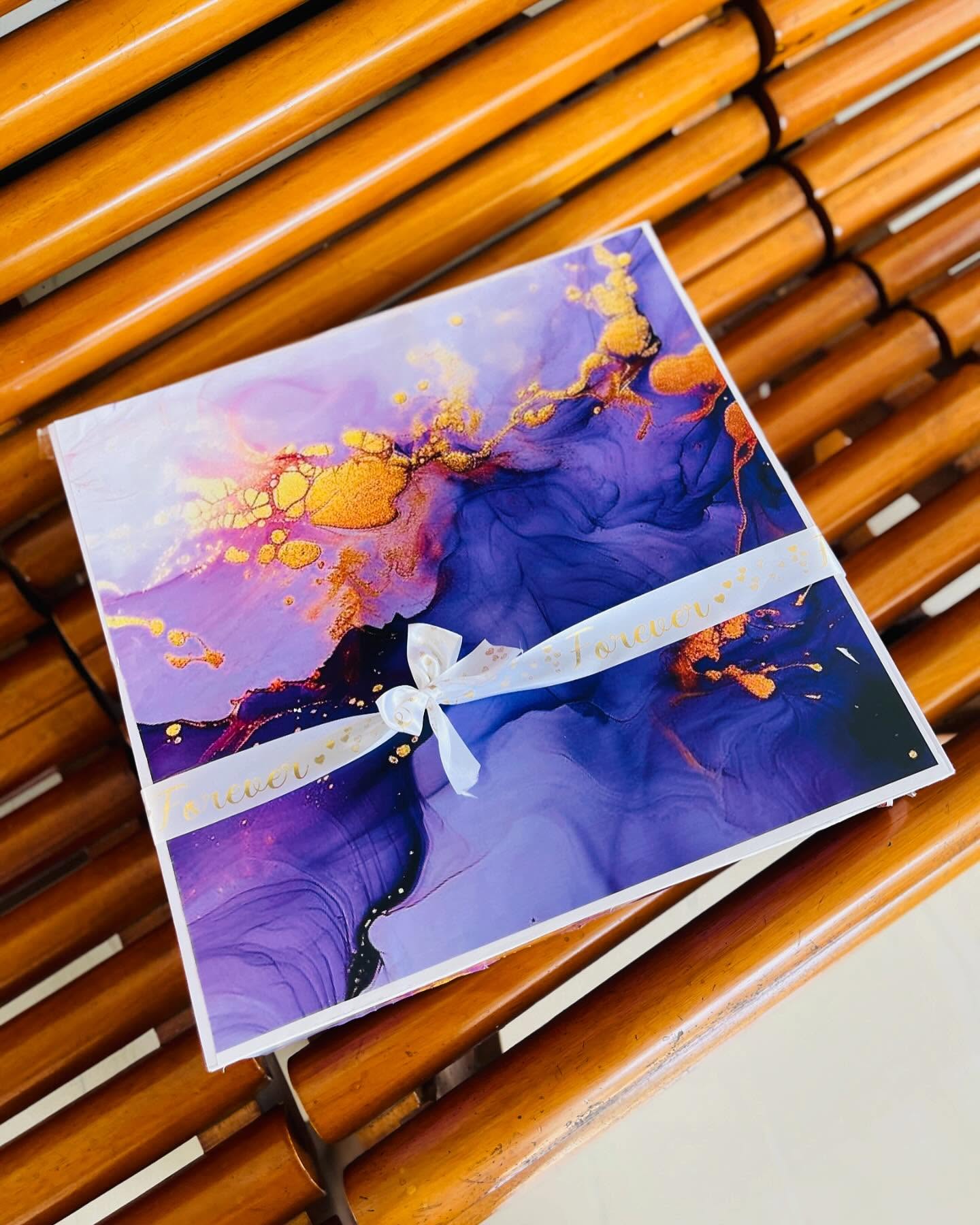 A premium gift box finished in a purple and gold marble design with a satin 'Forever' ribbon.