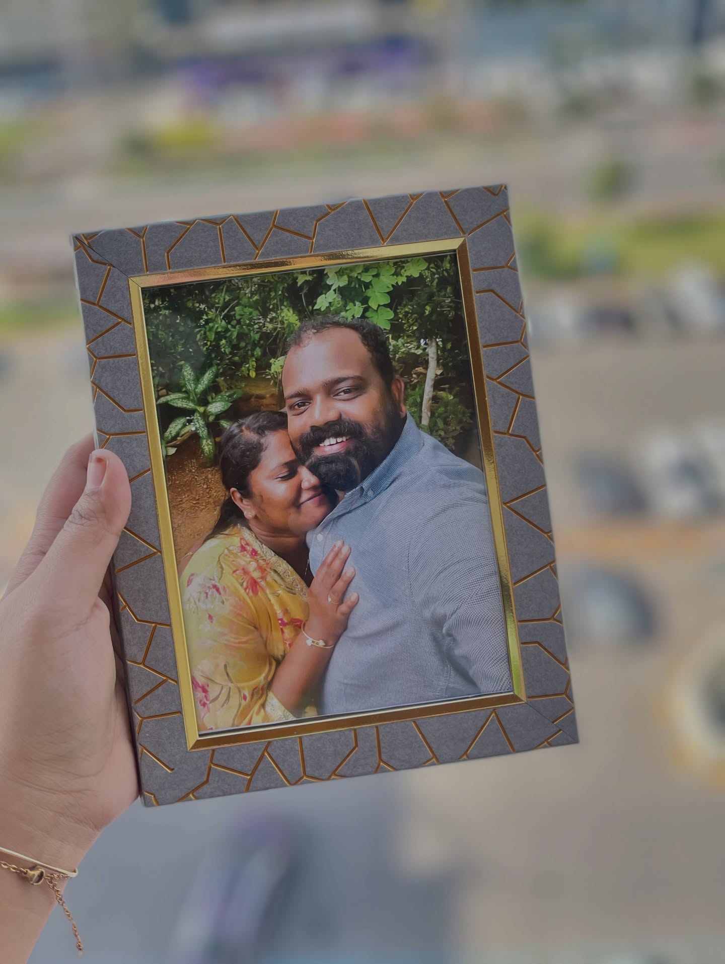 A warm, gold-trimmed photo frame capturing a candid couple portrait.