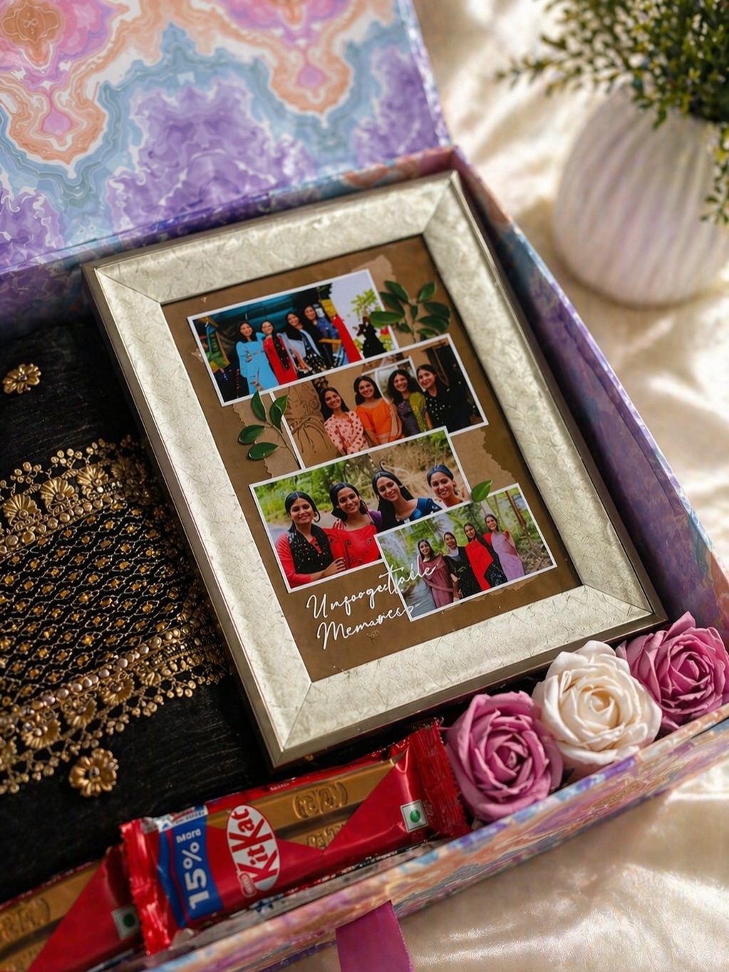 A marbled gift box with a framed friendship photo collage, silk roses, and a KitKat bar.