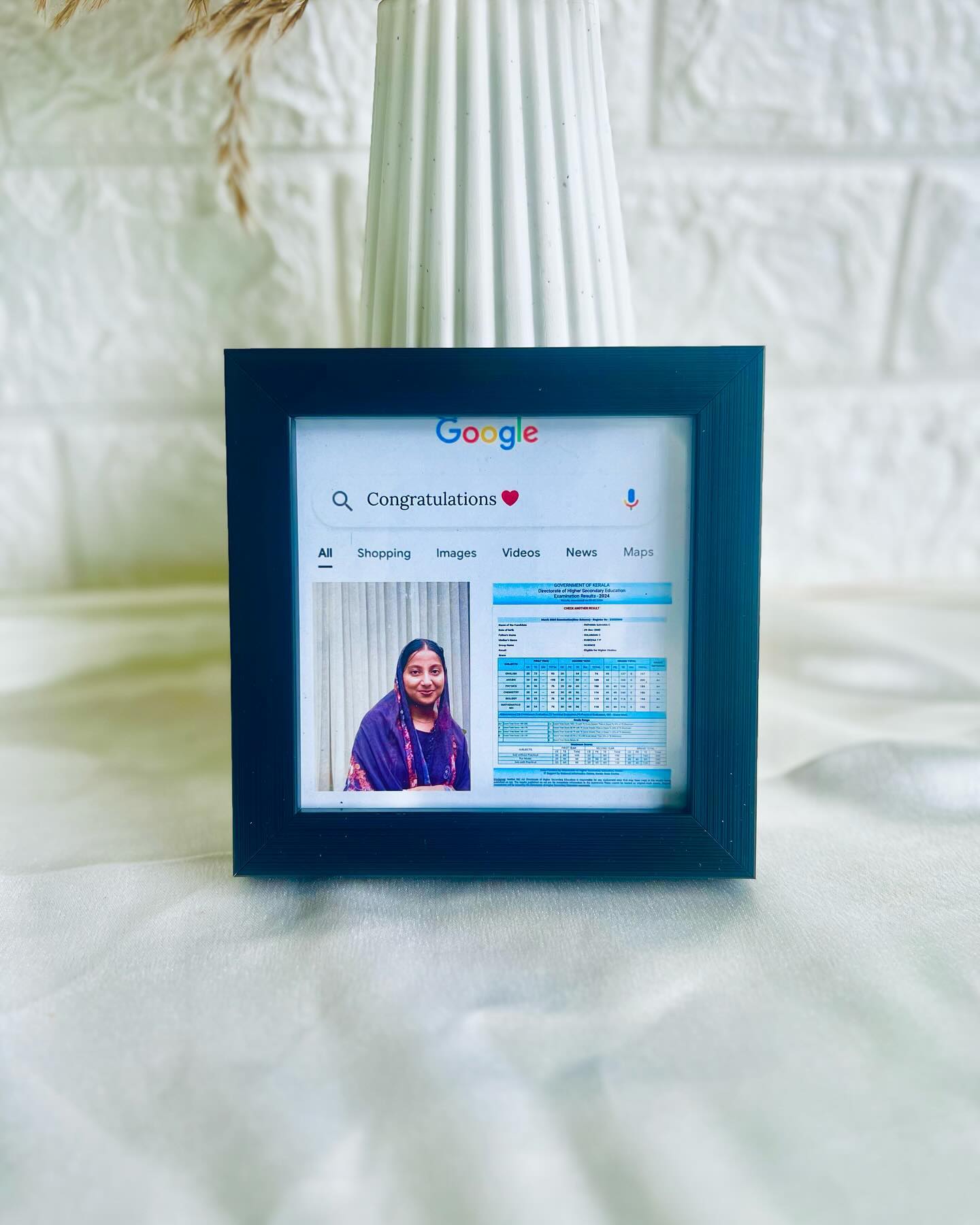 A playful framed print mimicking a Google search for "Congratulations," paired with a personal photo and achievement certificate.