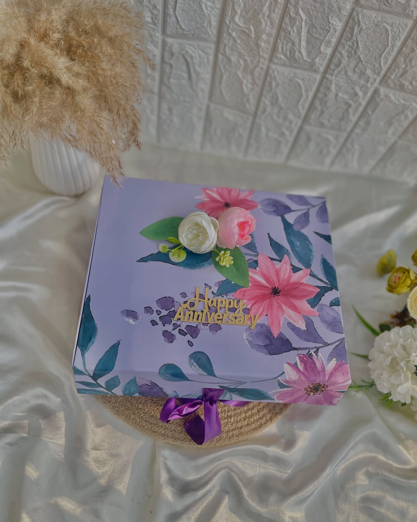 A lavender floral gift box finished with a satin ribbon, ready to be filled with anniversary surprises.