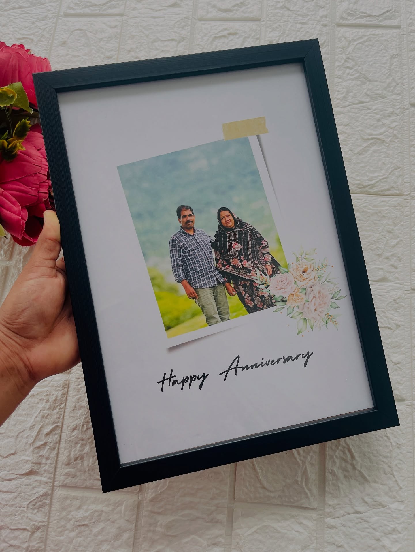 A personalized anniversary photo frame with a floral accent and printed message.