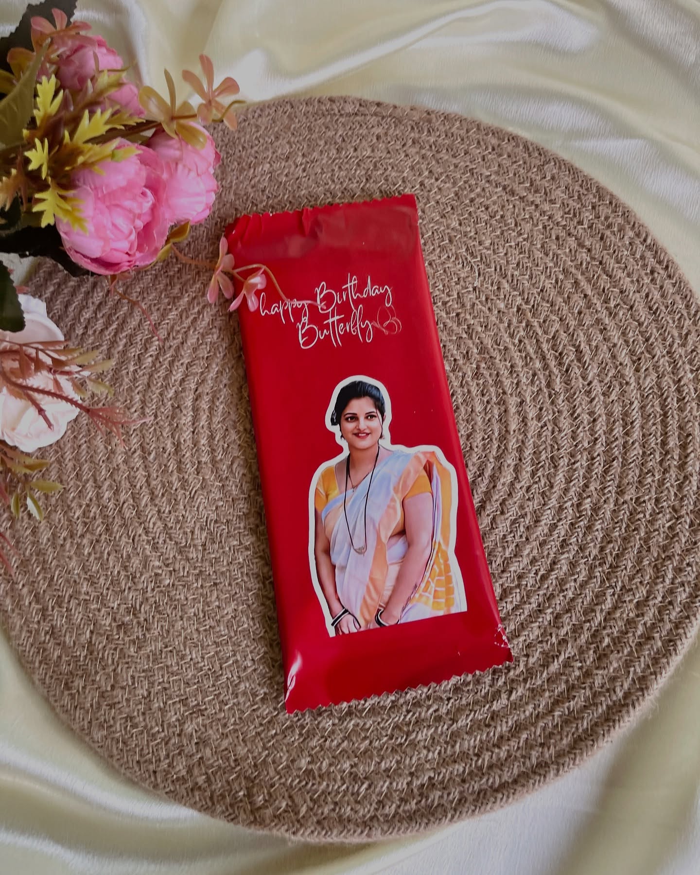 A red-wrapped chocolate bar personalized with a photo and a warm 'Happy Birthday Butterfly' message.