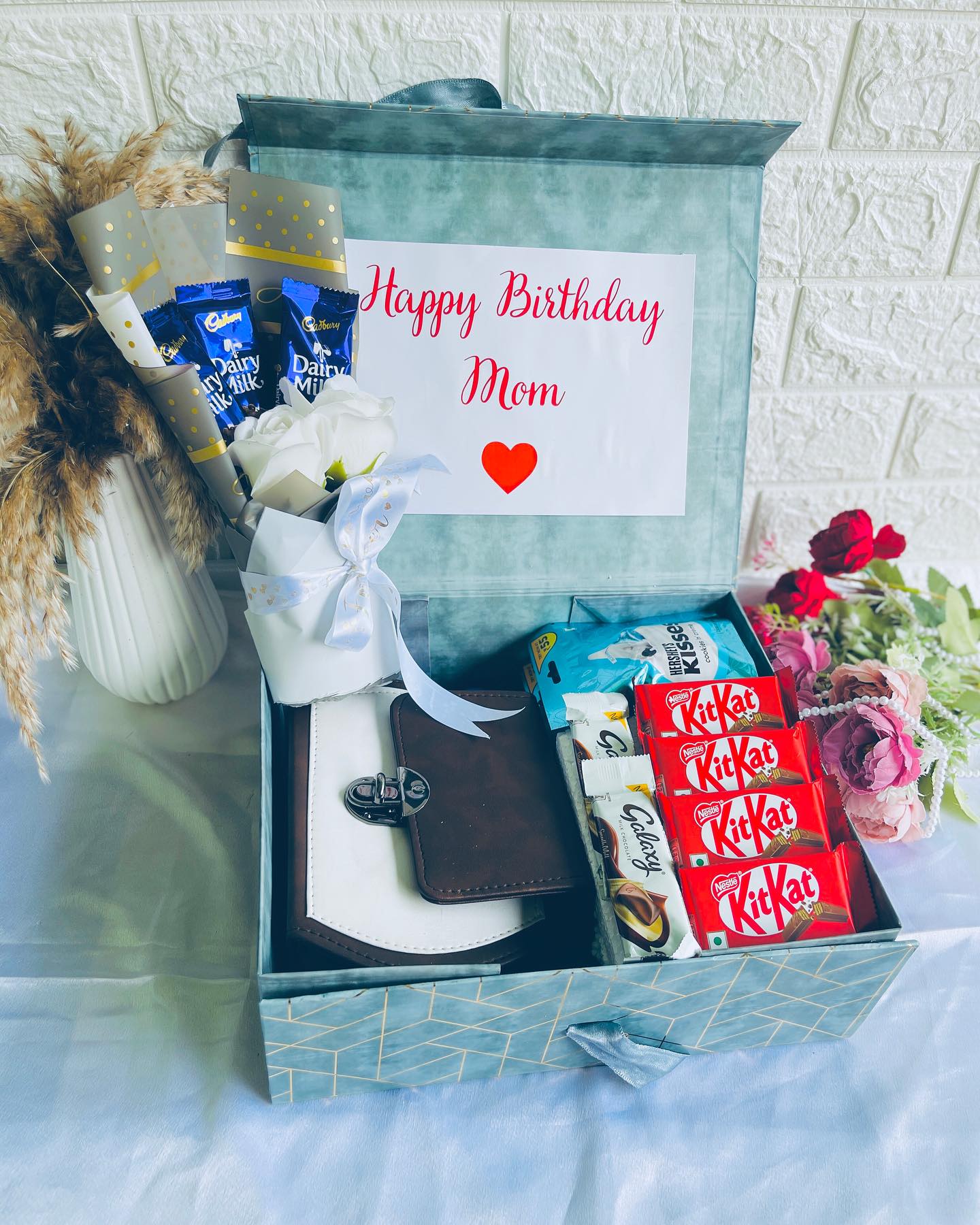A teal gift box for Mom with a chocolate bouquet, Cadbury and KitKat bars, Hershey's Kisses and a handbag.