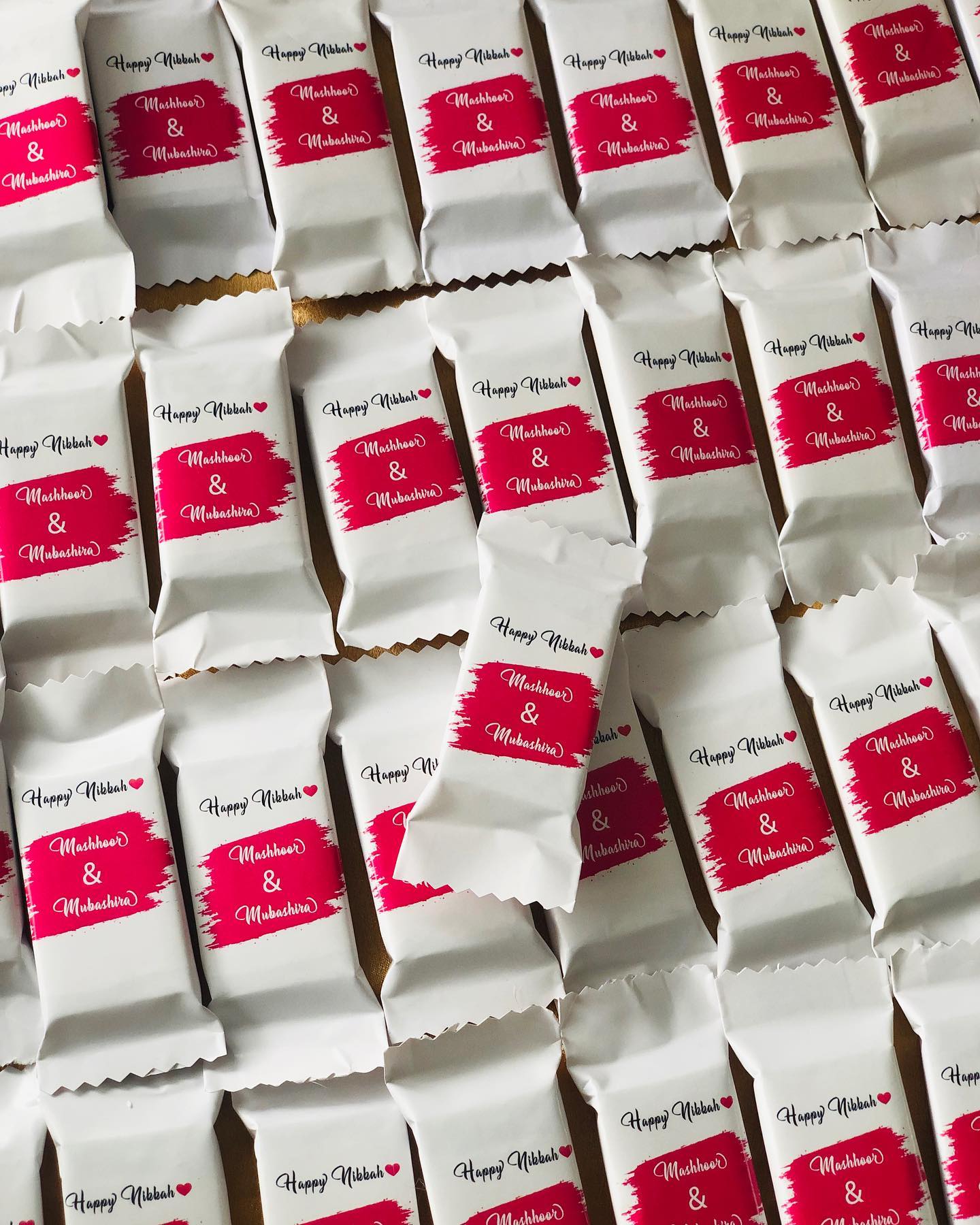 Individually wrapped chocolate bars personalized with the couple's names for Nikkah celebrations.