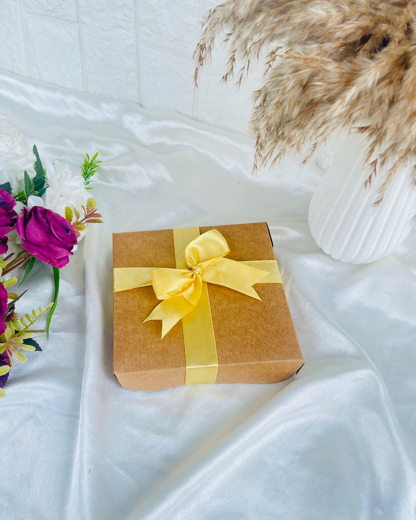 A neatly wrapped kraft gift box tied with a satin bow, ready for any sweet surprise.