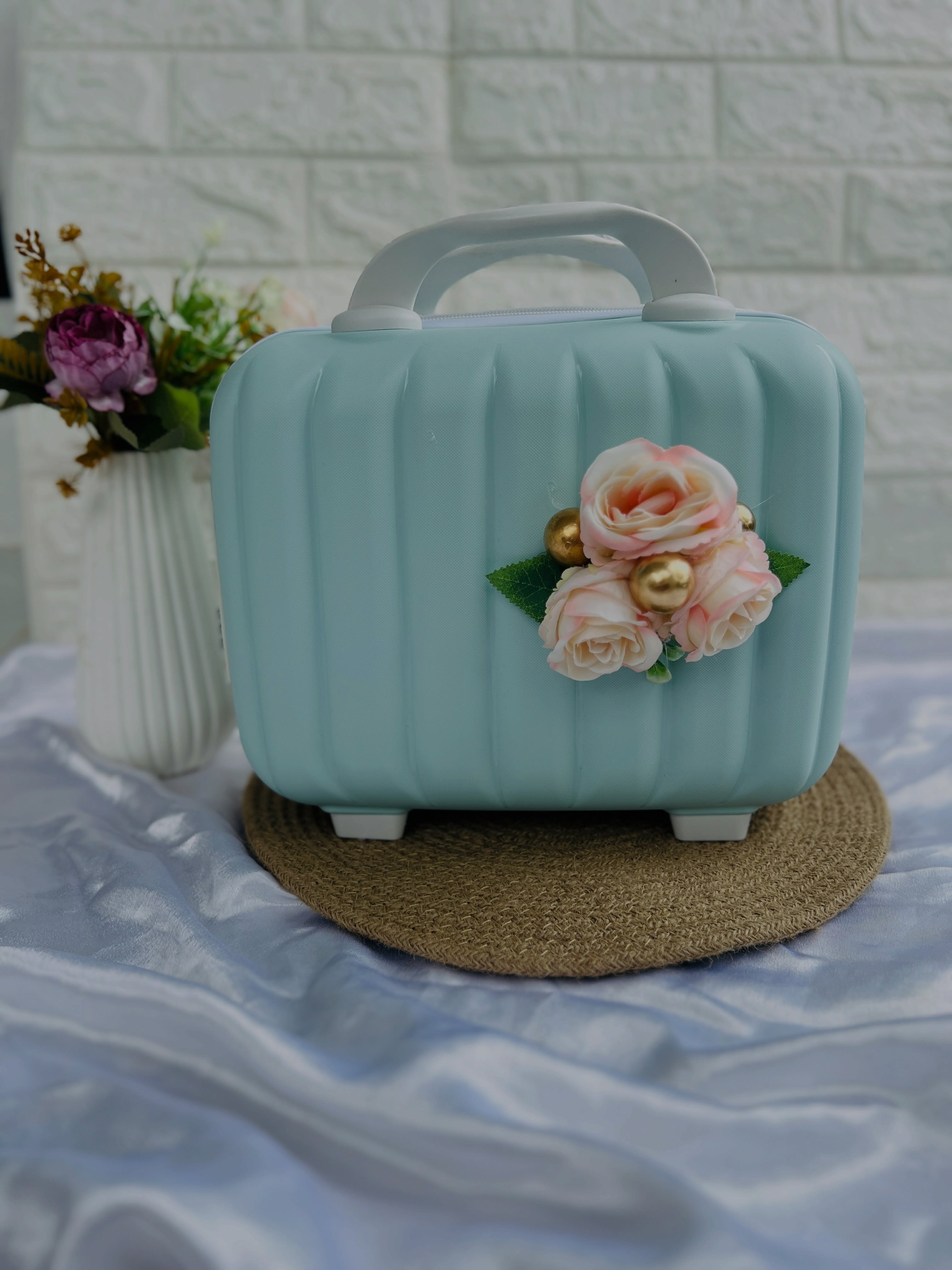 A pastel mint vanity case decorated with blush roses and gold beads, doubling as a stylish keepsake box.