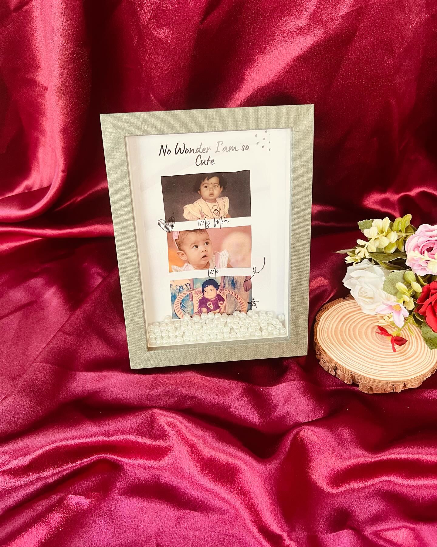 A charming shadow-box frame pairing childhood photos of mother and baby with a pearl-filled base.