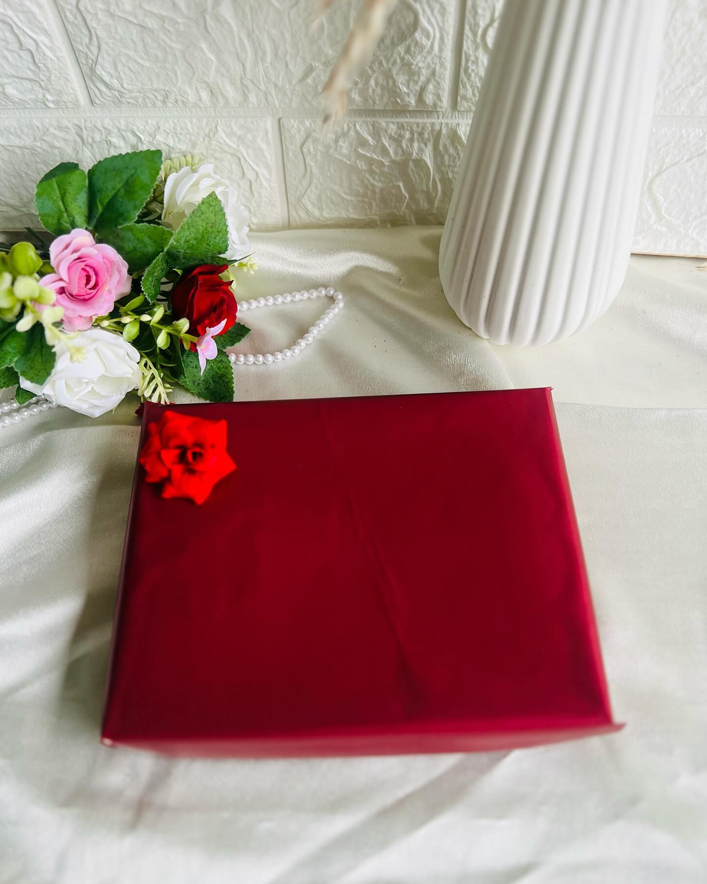 A deep red birthday box with a personalized photo frame, Dairy Milk chocolate, and a flip-ring polaroid photo album.