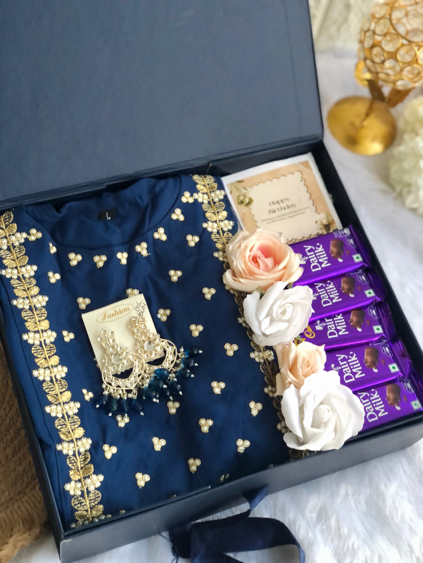 A festive birthday box with an embellished navy kurti, statement earrings, roses, and Dairy Milk chocolates.