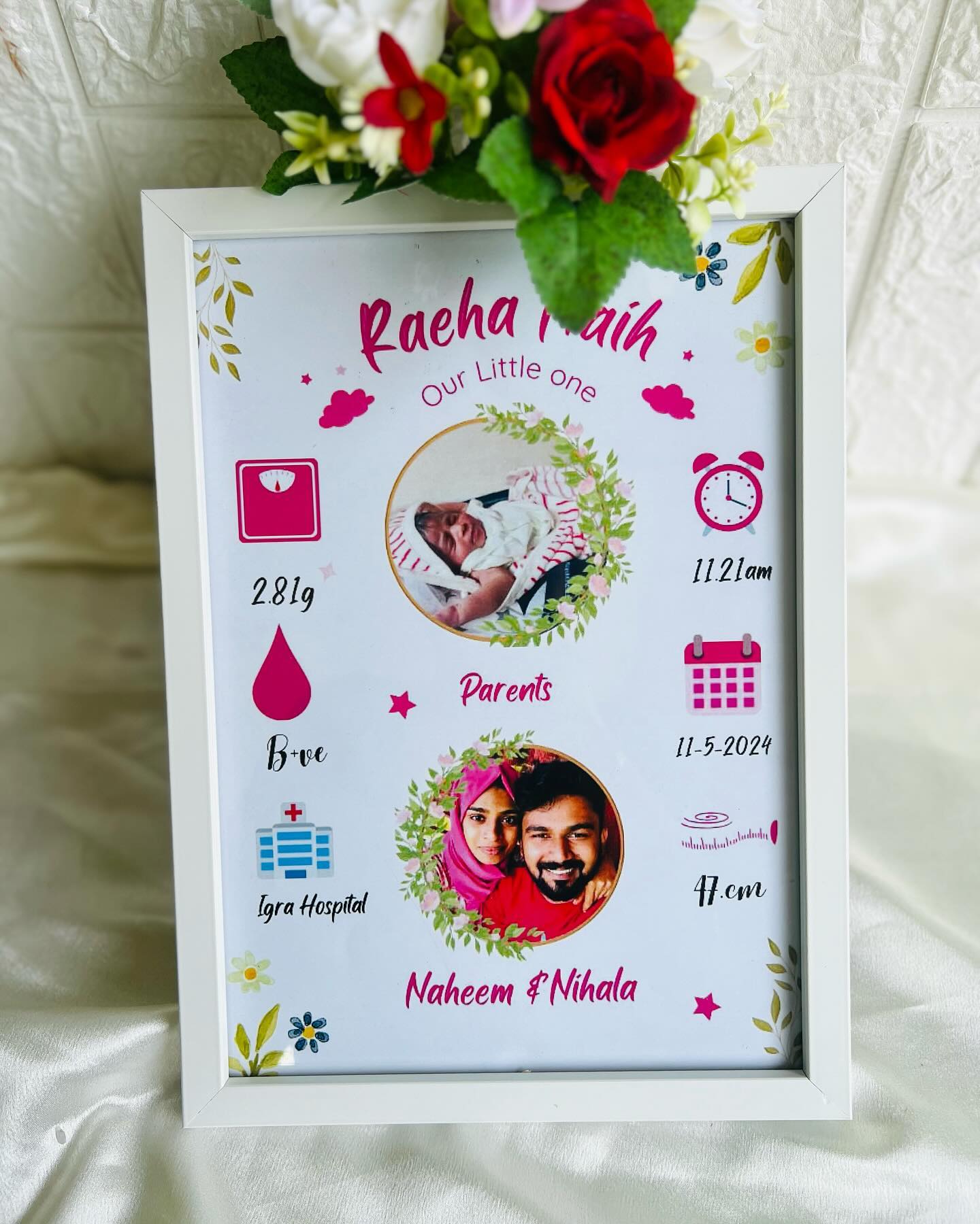 A pastel-illustrated framed poster capturing a newborn's stats, photo, and proud parents.