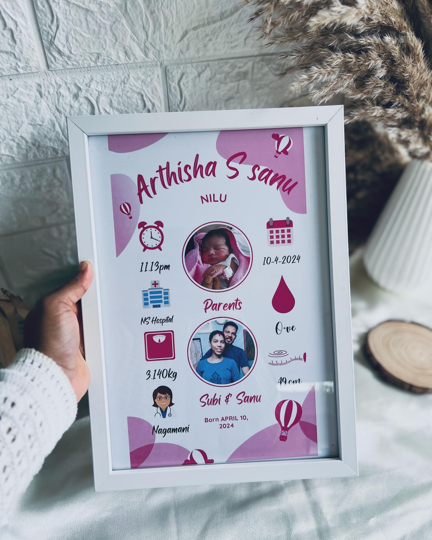 A pastel-pink personalized frame capturing baby Arthisha's birth details and parents' photo for a keepsake newborn gift.
