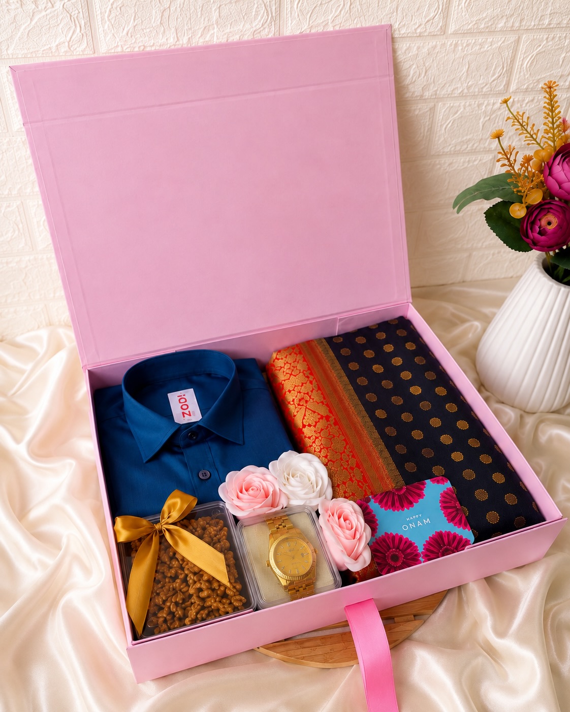 A premium Onam gift box with a shirt, a golden watch, a traditional set-mundu, sweets, and a festive greeting card.