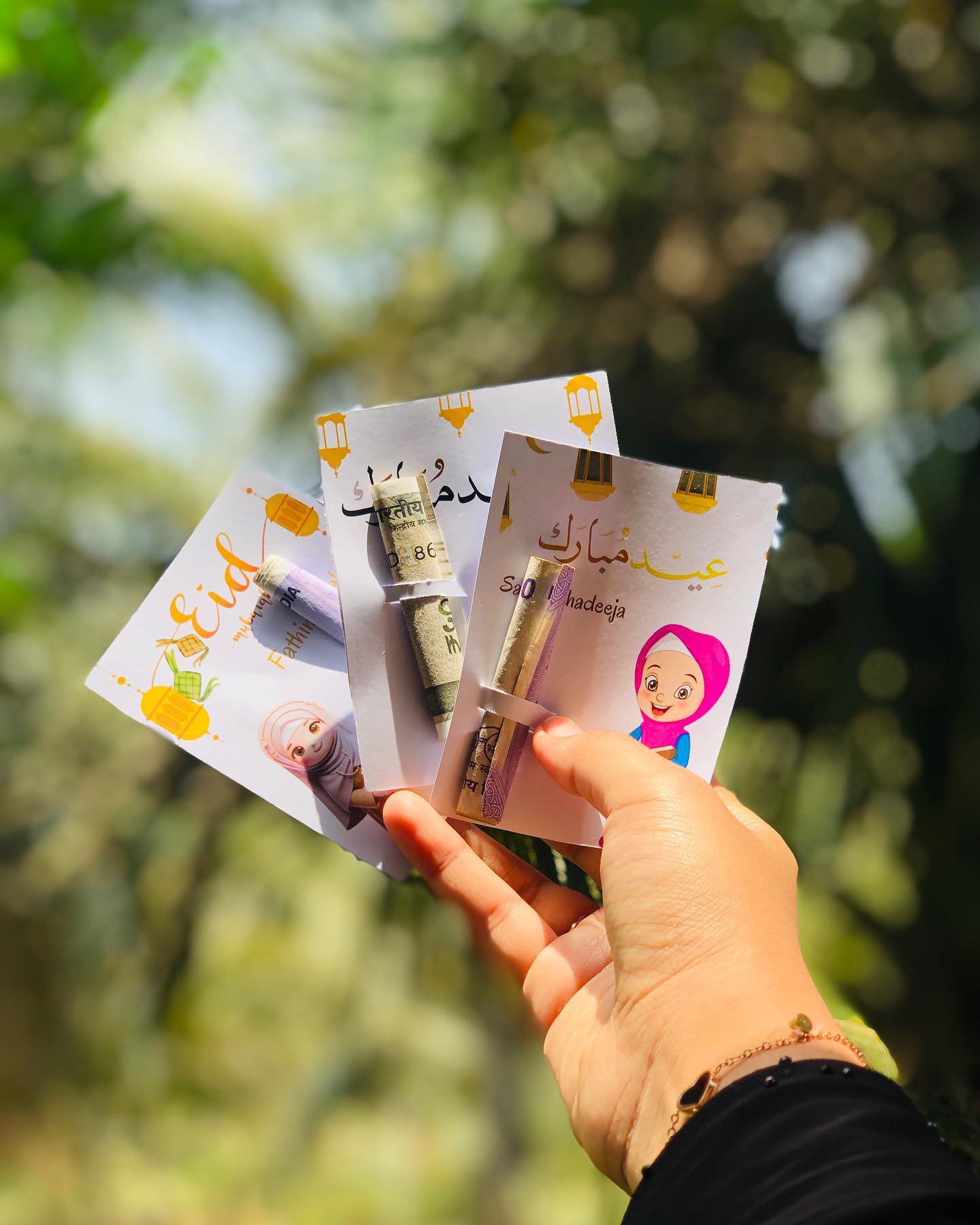 A set of custom-printed Eid Mubarak money envelopes, each personalized with the recipient's name.