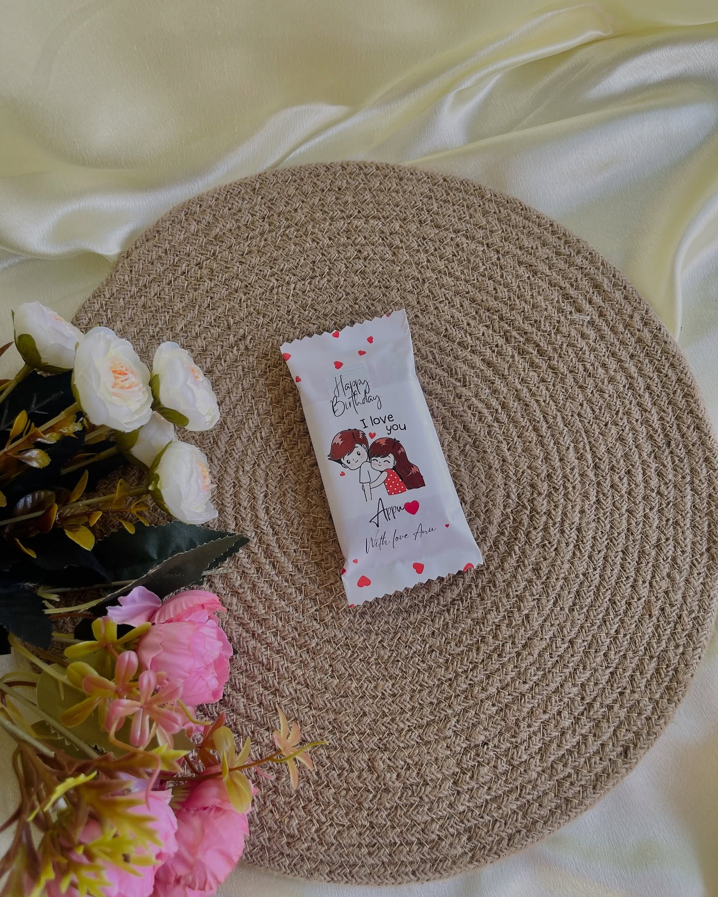 A single wrapped chocolate bar printed with a cute couple illustration and a personalized birthday love message.