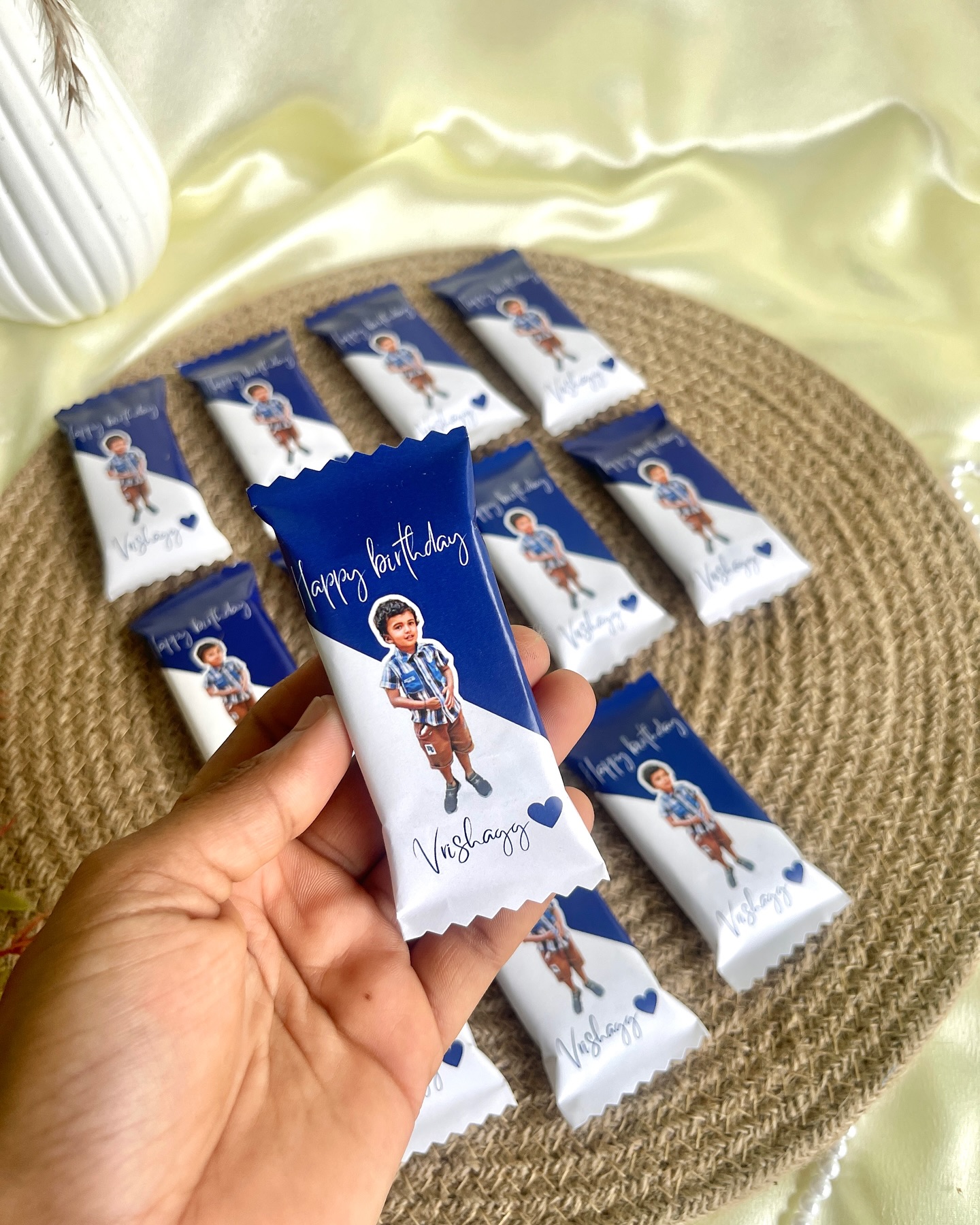 A bunch of mini chocolate bars individually wrapped in custom photo sleeves for a child's birthday celebration.