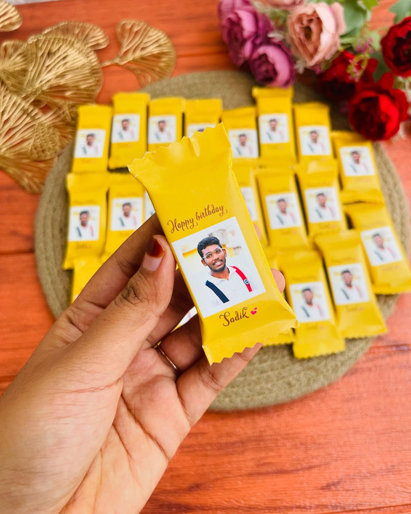 A batch of custom-wrapped chocolate bars printed with a photo and Happy Birthday message.