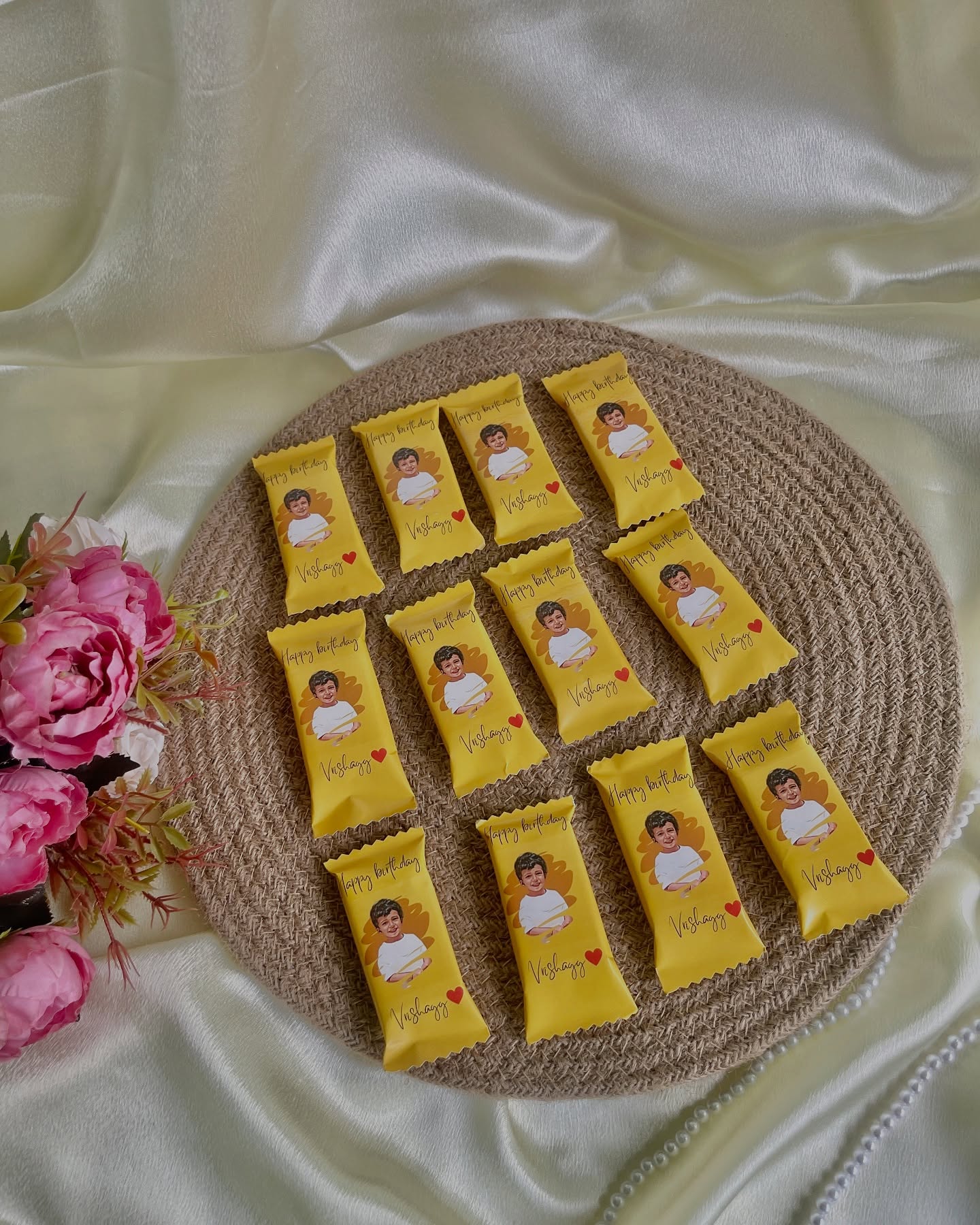 A tray of individually wrapped chocolate bars printed with a birthday photo and name, ready to share.