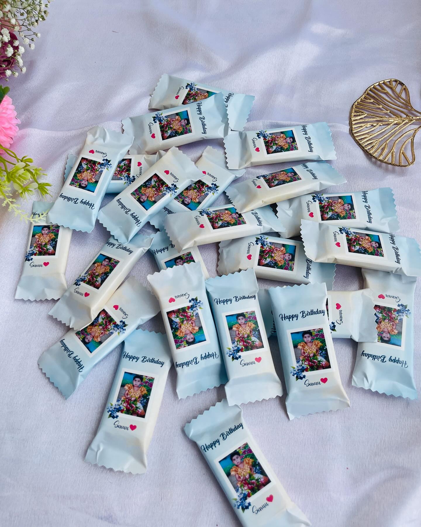 A bundle of individually wrapped chocolate bars personalized with a child's photo and a sweet birthday message.