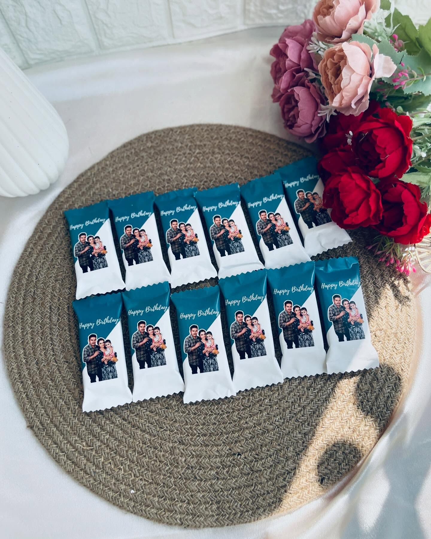 A dozen custom-wrapped chocolate bars printed with a family photo and "Happy Birthday" message.