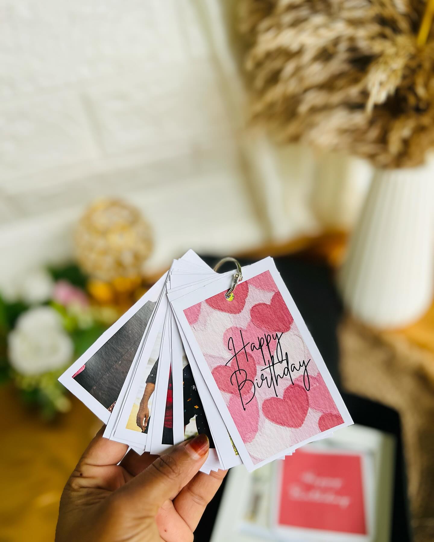 A ring-bound mini photo album keychain with a Happy Birthday heart-print cover.
